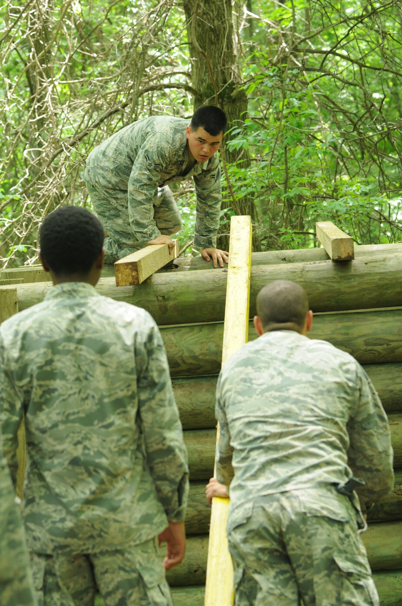 Newer members of the 910th Airlift Wing Security Forces Squadron in the Seasoning Training Program work on a team-building exercises at a rope course at Camp Ravenna, Ohio, June 27th, 2014. The Airmen attended and participated in the course with Junior Reserve Officer Training Corps members. Seasoning training allows 3-skill level Airmen to voluntarily remain on active duty for training as they upgrade to 5-level through on-the-job training. U.S. Air Force photo/Eric M. White.