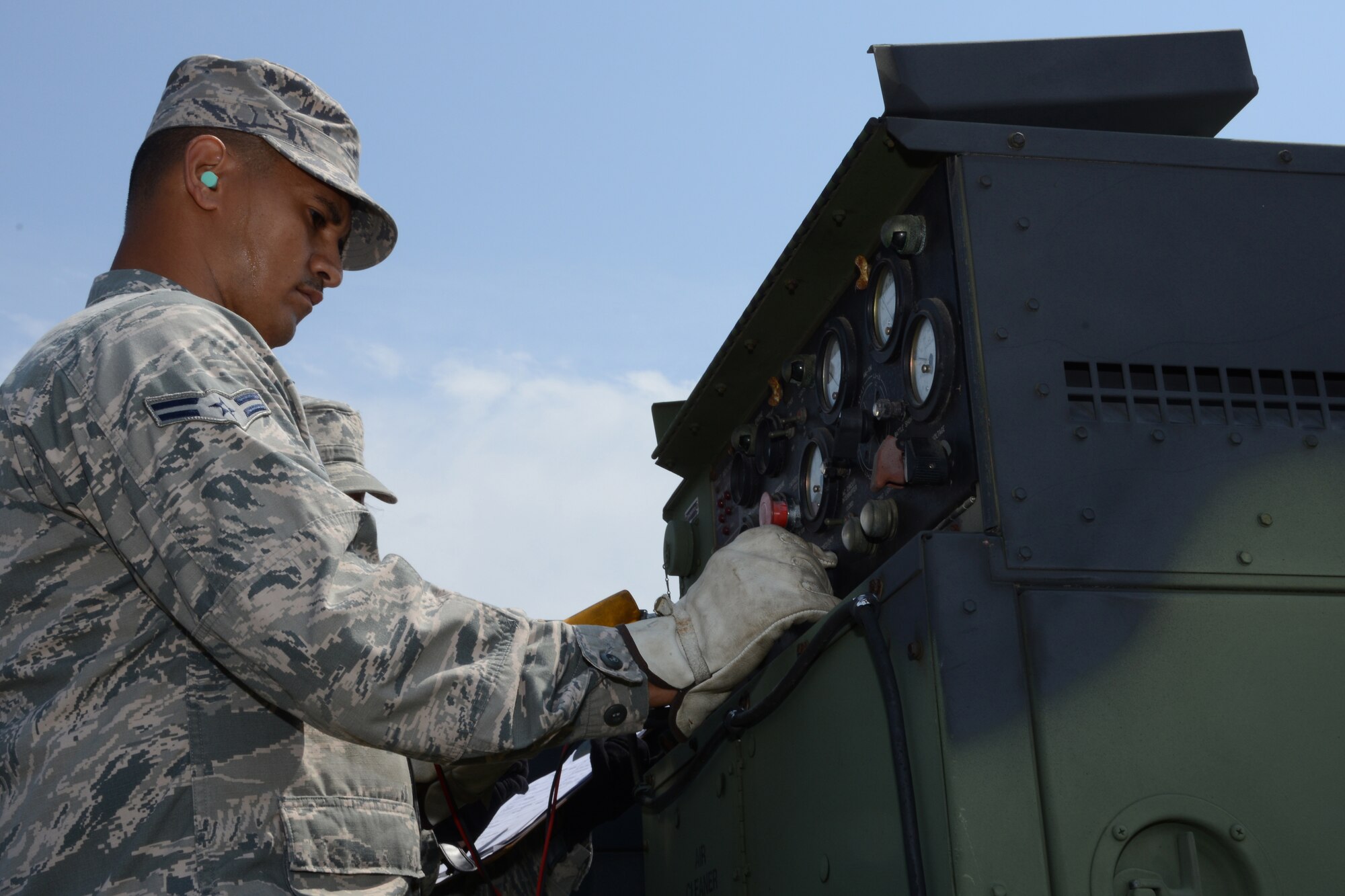 Airman 1st Class Erin Cruz, an aerospace ground equipment technician from the 103rd Air Control Squadron, performs maintenance on one of the generators that supply power to the unit’s tactical site while deployed to the National Guard Training Center, Sea Girt, N.J., June 10.  The unit operated in field conditions using generated power to enable operators to command and control simulated military aircraft from the field. (U.S. Air National Guard photo by Senior Airman Emmanuel Santiago) 