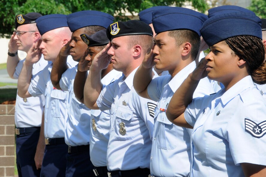 HANSCOM AIR FORCE BASE, Mass. -- Airmen from across the 66th Air Base Group salute as the flag is retrieved during a retreat ceremony outside Building 1305 July 7. Members of 66 ABG participated along with the Patriot Honor Guard in the formal retreat ceremony. A retreat ceremony serves a two-fold purpose: It signals the end of the official duty day and serves as a ceremony for paying repsect to the flag. (U.S. Air Force photo by Linda LaBonte Britt)