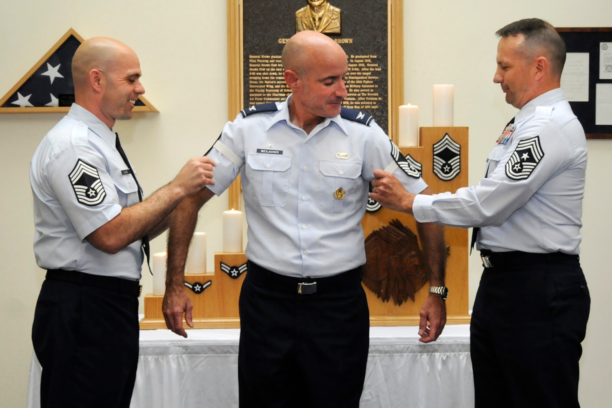 HANSCOM AIR FORCE BASE, Mass. – Hanscom Command Chief Master Sgt. Craig A. Poling (right), and Chief Master Sgt. Gerard J. Nunes Jr. (left), 66th Security Forces Squadron manager, present Col. Lester A. Weilacher, former 66th Air Base Group commander, chief master sergeant stripes during an honorary chief ceremony in the Brown Building lobby July 7. Weilacher was nominated by the Hanscom Chief’s Group to the honorary position as a result of his support to the Hanscom enlisted corps during his time as commander. (U.S. Air Force photo by Linda LaBonte Britt)