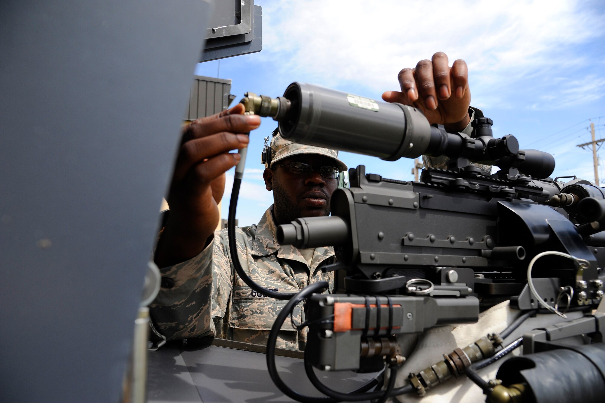 Senior Airman Andrae Goode, 341st Communications Squadron visual imagery and intrusion detection systems technician, calibrates a Remote Targeting Engagement System camera on a final denial system July 10. Routine maintenance and repair of all systems, mechanical and electrical, is a critical part of communications personnel activities. (U.S. Air Force photo/Airman 1st Class Collin Schmidt)