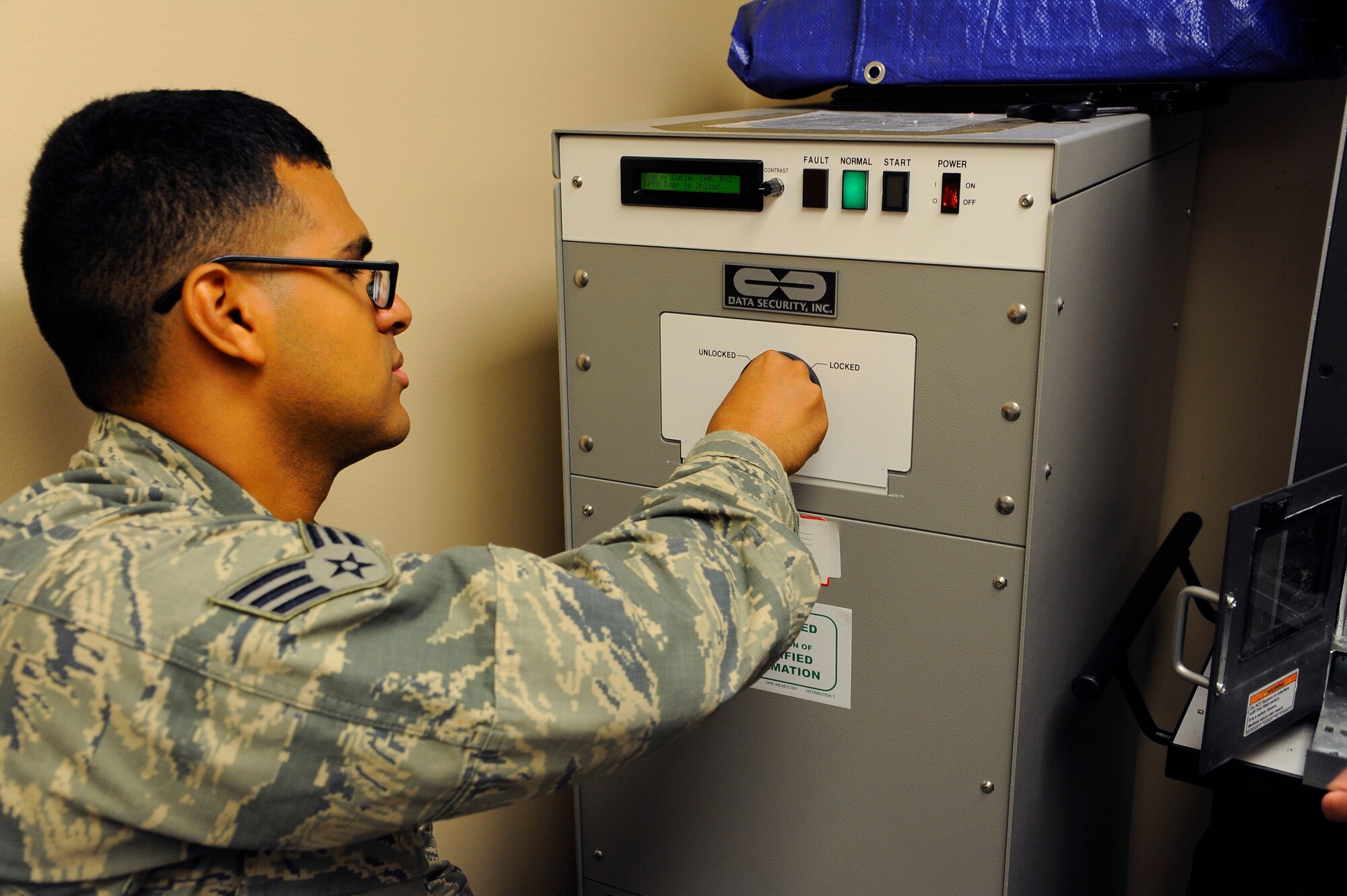 Senior Airman Anthony Zamudio, 341st Communications Squadron client systems technician, uses a degaussing machine to erase hard drive data July 10 before physically destroying the drive. To safely dispose of confidential information, a detailed process must be followed which includes complete destruction of the hardware components.  (U.S. Air Force photo/Airman 1st Class Collin Schmidt)