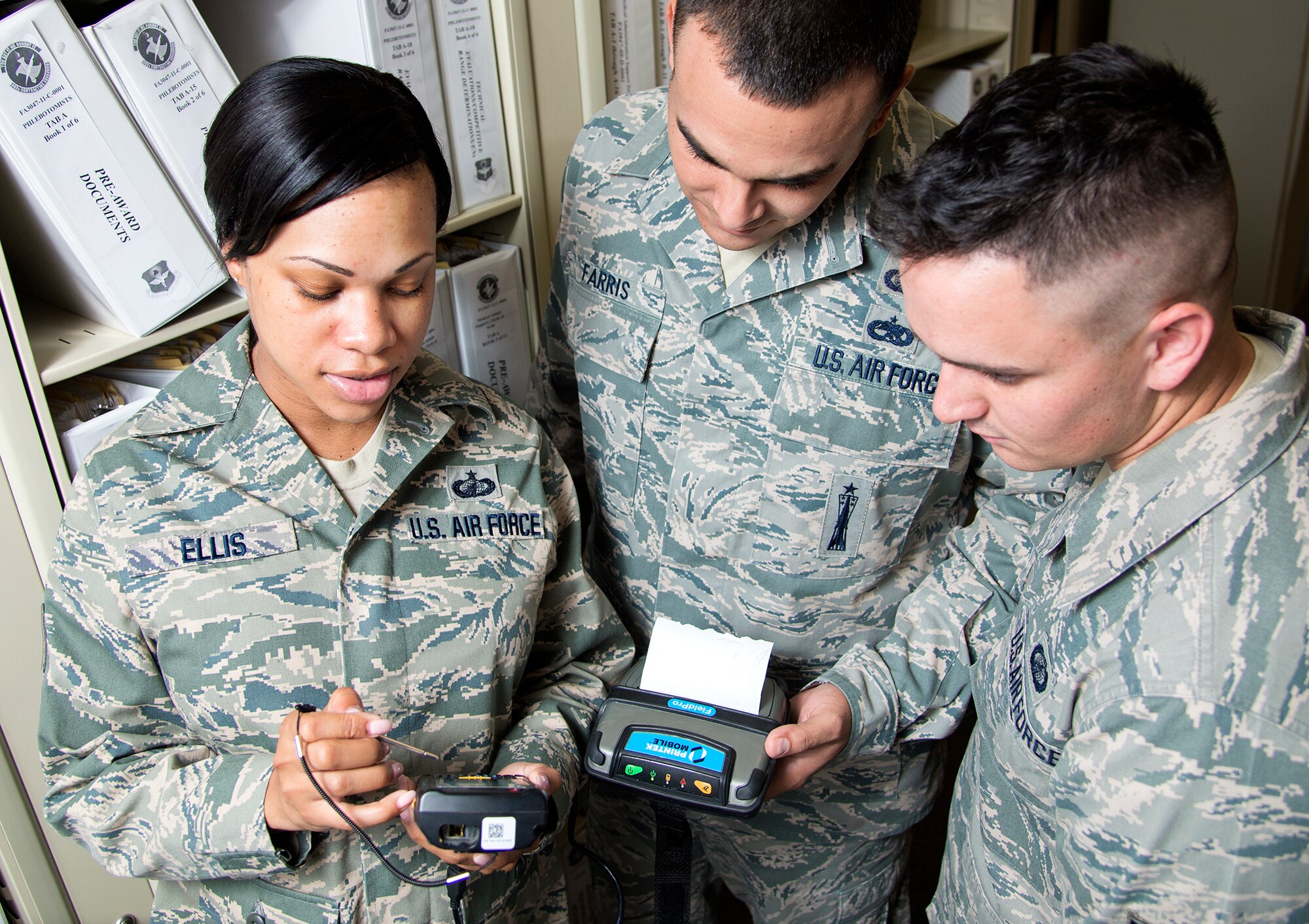 Tech. Sgt. Latoria Ellis, 502nd Contracting Squadron contracting officer, provides instruction to Staff Sgt. Ronald Farris and Airman 1st Class Philip Napier June 26, at Joint Base San Antonio-Lackland.  Tech. Sgt. Ellis recieved the 12th Outstanding Airman of the Year award for 2014. (U.S. Air Force photo by Benjamin Faske) (released)