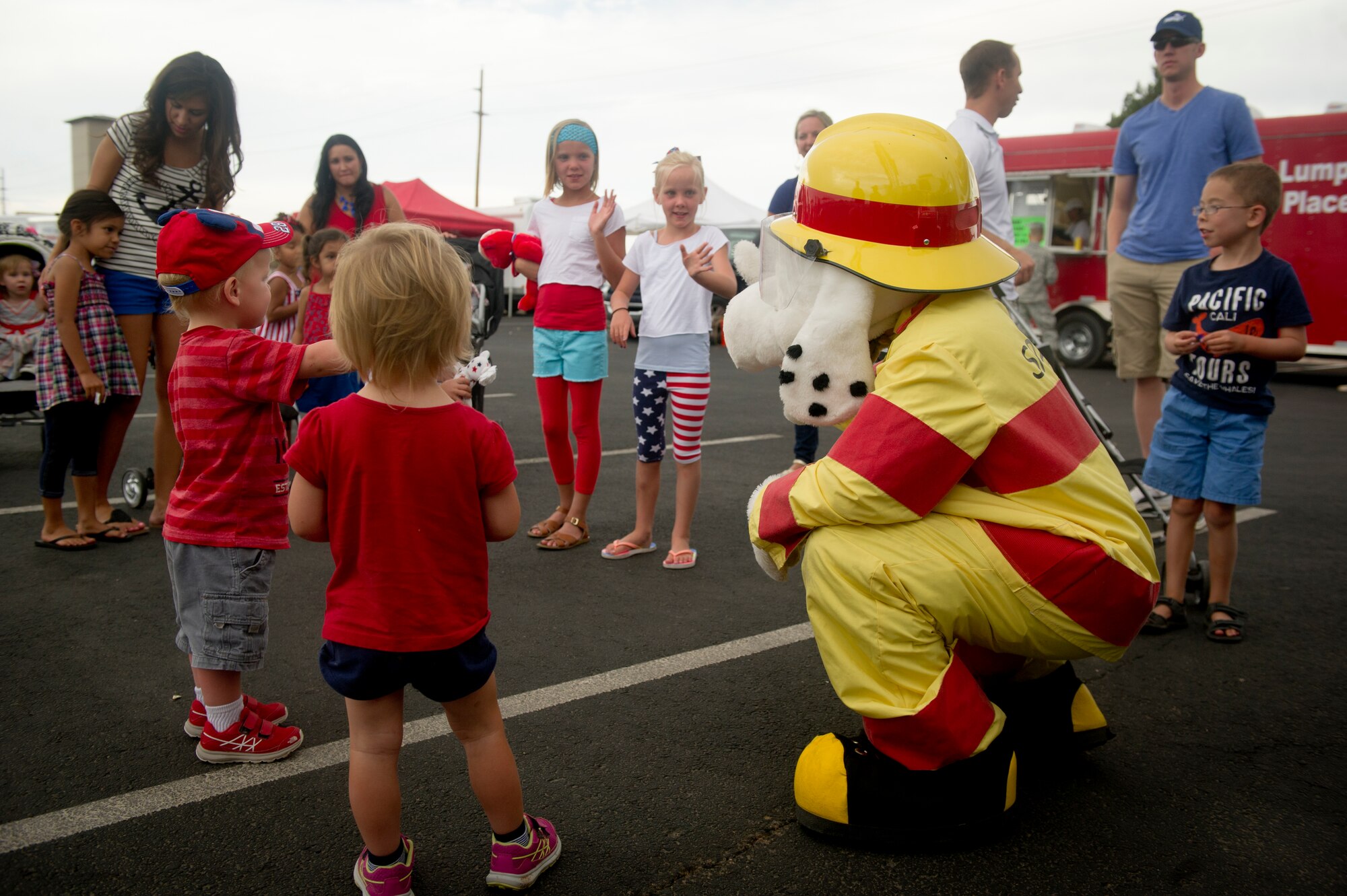 Children interact with Sparky the Fire Dog during the Freedom Fest Independence Day celebration at Holloman Air Force Base N.M., July 3. Sparky and 49th Civil Engineer Squadron firefighters were at the celebration to give tours of the fire trucks, show off their fire-fighting equipment, and raise fire-safety awareness. The Freedom Fest, which took place in the Domenici Fitness and Sports Center parking lot, also included carnival games, rides, live music, and a fireworks display for Airmen and their families. (U.S. Air Force photo by Airman 1st Class Aaron Montoya/Released)