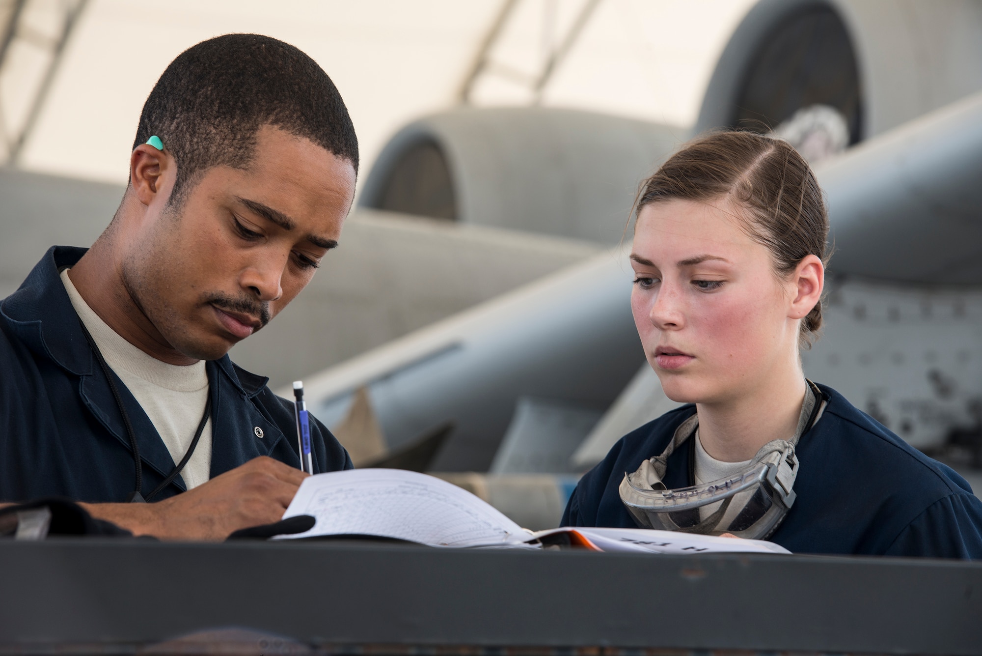 U.S. Air Force Staff Sgt. Danny Barthelemy Jr., left, and Airman 1st Class Robin Burke, both 23d Aircraft Maintenance Squadron dedicated crew chiefs, fill out a post-flight ‘Joap report’ at Moody Air Force Base, Ga., July 9, 2014. A Joap report summarizes information on collected engine oil samples, which are analyzed after each flight to ensure the engines are functioning properly. (U.S. Air Force photo by Airman 1st Class Ryan Callaghan/Released)