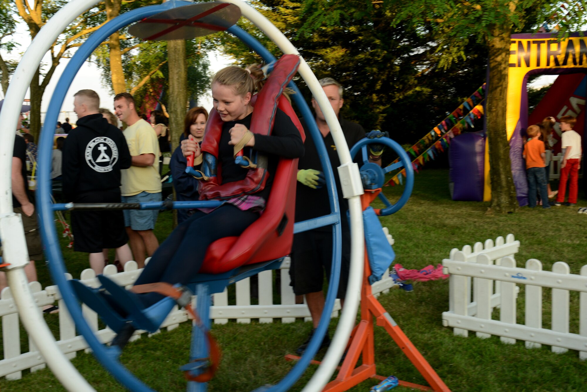 A young girl braces herself during a gyroscope ride at the Fourth of July festival on RAF Croughton, United Kingdom, July 3, 2014. During the celebration, patrons enjoyed rides, games, fireworks and even a parachute jump demonstration. (U.S. Air Force photo by Tech. Sgt. Chrissy Best/Released)