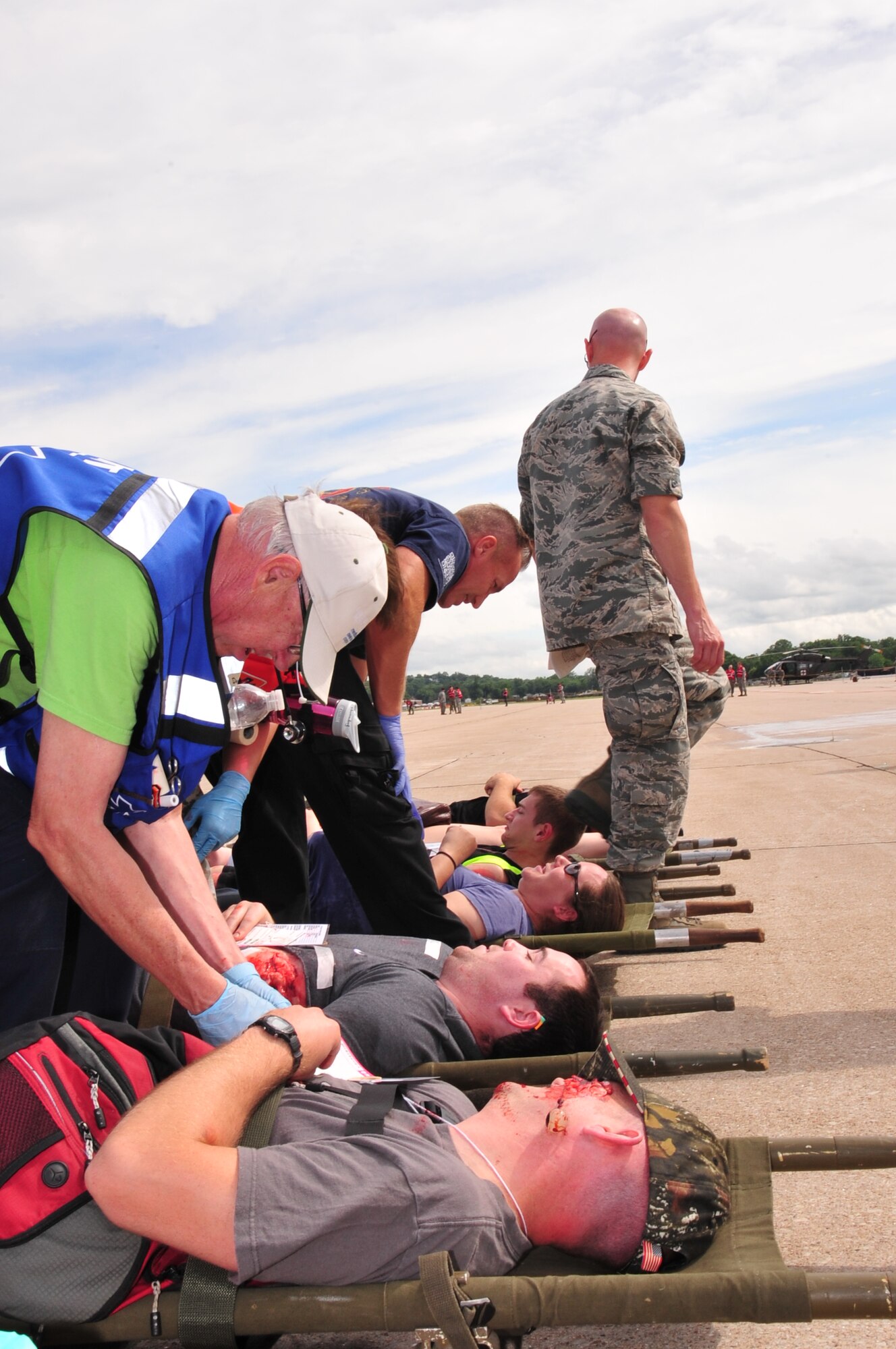 First responders from Offutt Air Force Base, Nebraska, and surrounding communities administer first aid to the wounded during a mock emergency on Offutt’s flight line June 28. First responders from the 55th Wing and the surrounding communities participated in this annual training to prepare the community for a major incident during an air show. (U.S. Air Force photo by D.P. Heard/Released)
