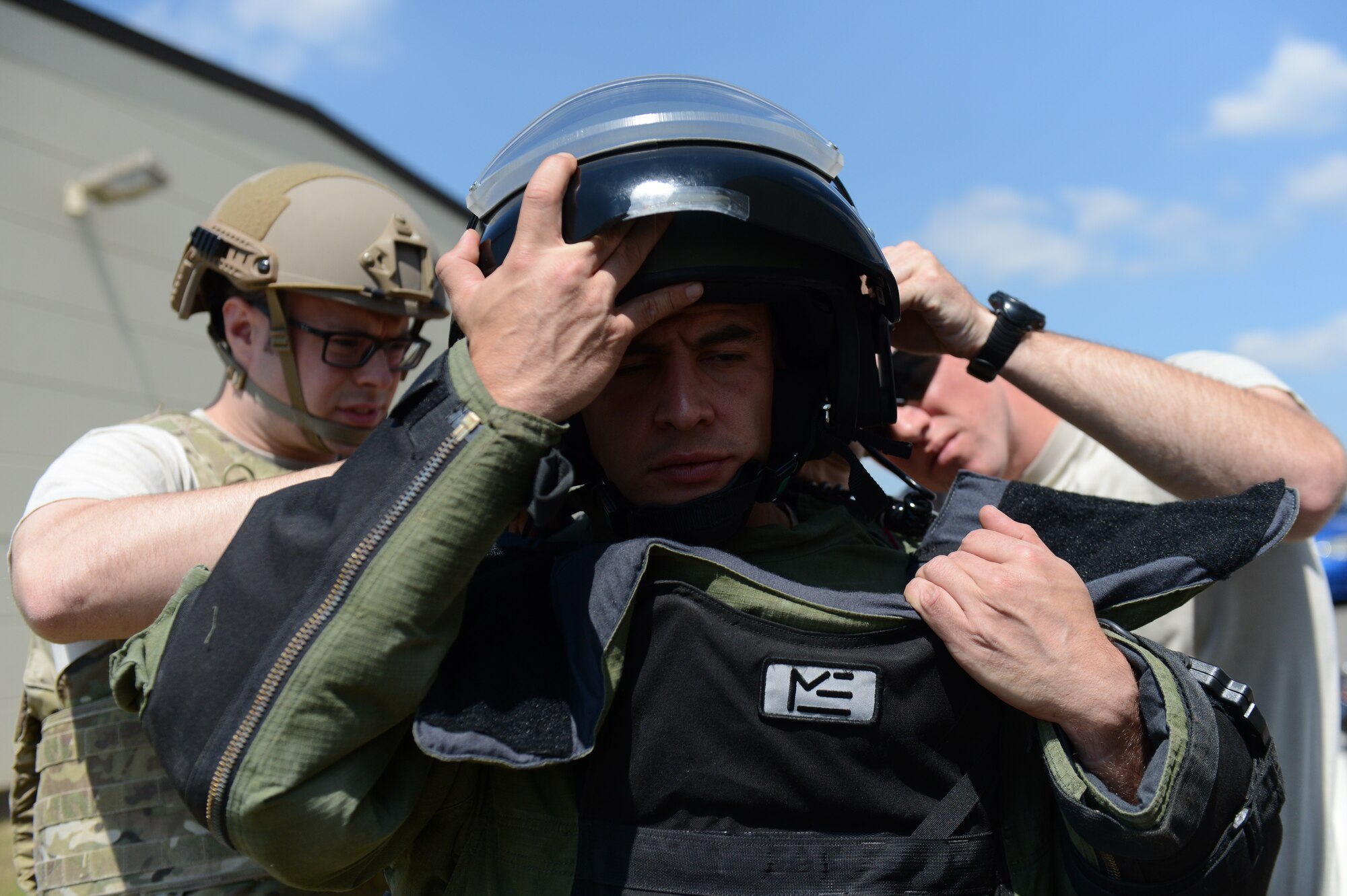 U.S. Air Force Staff Sgt. Brook Hamilton, a 52nd Civil Engineer Squadron explosive ordnance disposal technician from Phoenix, helps U.S. Air Force Tech. Sgt. Ryan Tennyson, right, a 52nd CES EOD technician from Norwich, Conn., don an explosive protective suit during a suspicious-package exercise at Spangdahlem Air Base, Germany, July 2, 2014. Airmen wear the suit because its design allows it to withstand bomb damage. (U.S. Air Force photo by Senior Airman Gustavo Castillo/Released)