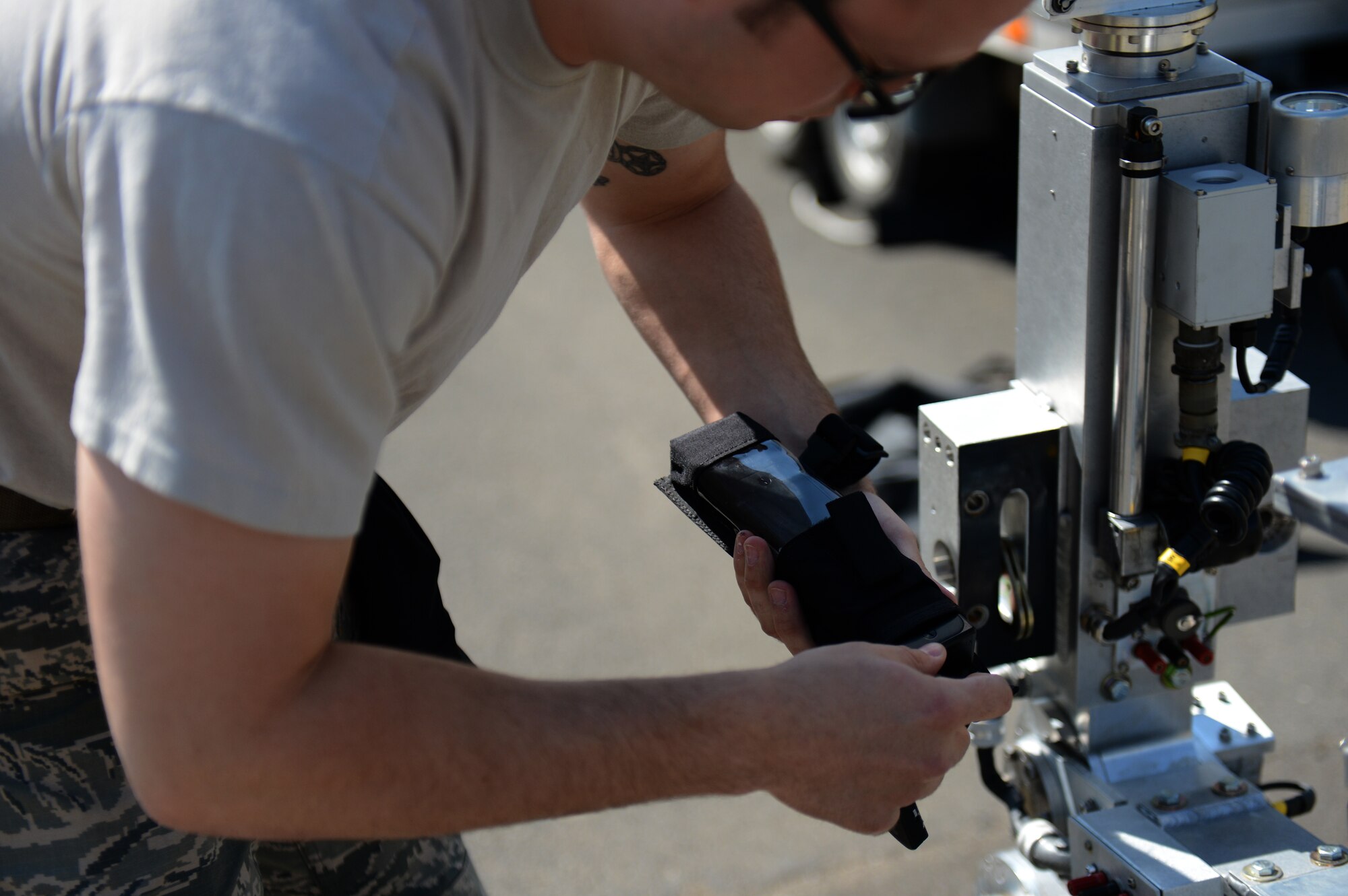U.S. Air Force Staff Sgt. Brook Hamilton, a 52nd Civil Engineer Squadron explosive ordnance disposal technician from Phoenix, attaches a radiation monitor to an ANDROS F-6A EOD robot during a suspicious package exercise at Spangdahlem Air Base, Germany, July 2, 2014. EOD technicians use radiation and chemical weapon monitors to ensure a safe environment before sending in an expert to survey the scene. (U.S. Air Force photo by Senior Airman Gustavo Castillo/Released) 