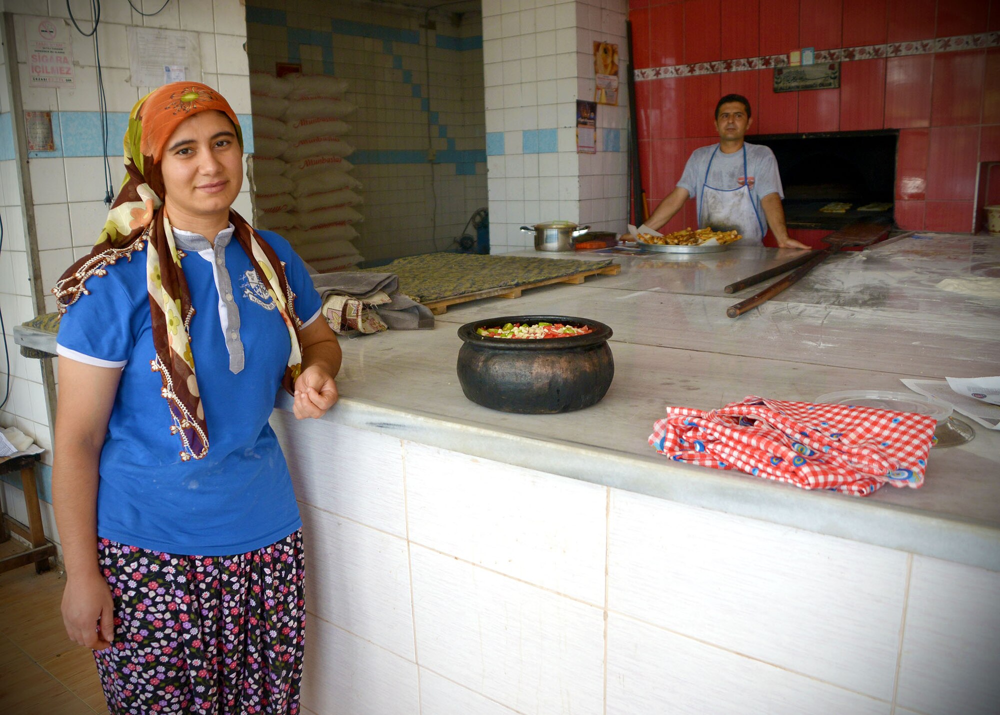 A woman poses in front of a stone pot at a local bakery July 9, 2014, near Incirlik Air Base, Turkey. Many Muslims in Turkey participate in fasting for Ramazan, during this time they will not eat or drink during daylight hours. Bakeries offer specialty breads during Ramazan after the fasting period. (U.S. Air Force photo by Staff Sgt. Veronica Pierce/Released)