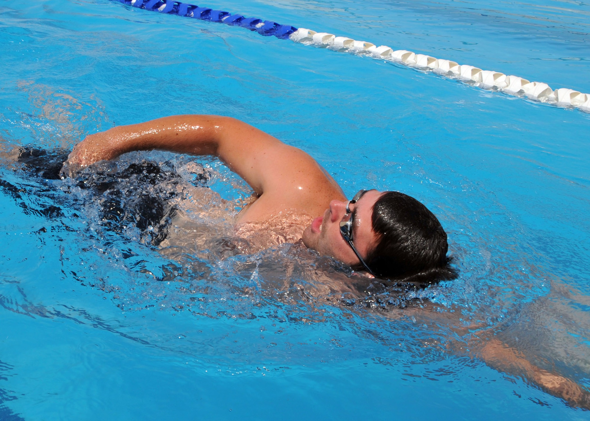 A swimmer swims laps in the 380th Air Expeditionary Wing pool during his off-duty hours at an undisclosed location of Southwest Asia on July 4, 2014. (U.S. Air Force photo by Senior Master Sgt. Eric Peterson/Released)