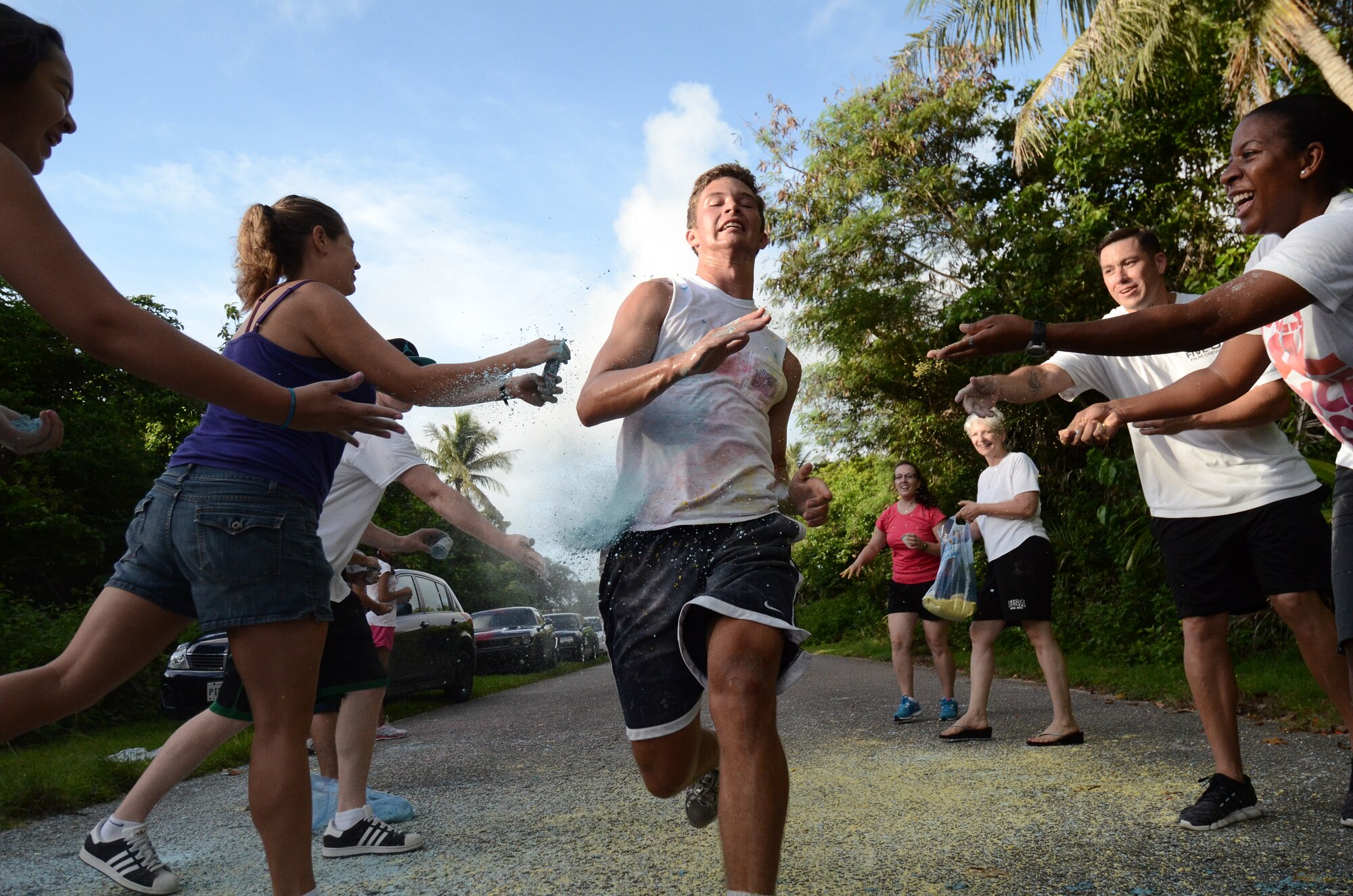 A participant is dusted with color during the Andersen Freedom Blast 5K Color Run July 3, 2014, on Andersen Air Force Base, Guam. The 36th Force Support Squadron Airmen prepared 400 pounds of food colored cornstarch in the six weeks prior to this run. (U.S. Air Force photo by Airman 1st Class Emily A. Bradley/Released)