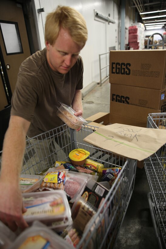 Steven Doyle sorts a cart of unsellable items at the Cherry Point Commissary for donation to the Food Bank of Central and Eastern North Carolina July 2, 2014. Doyle is a commissary worker who helped pack more than 30,000 pounds of food for donation since February.


