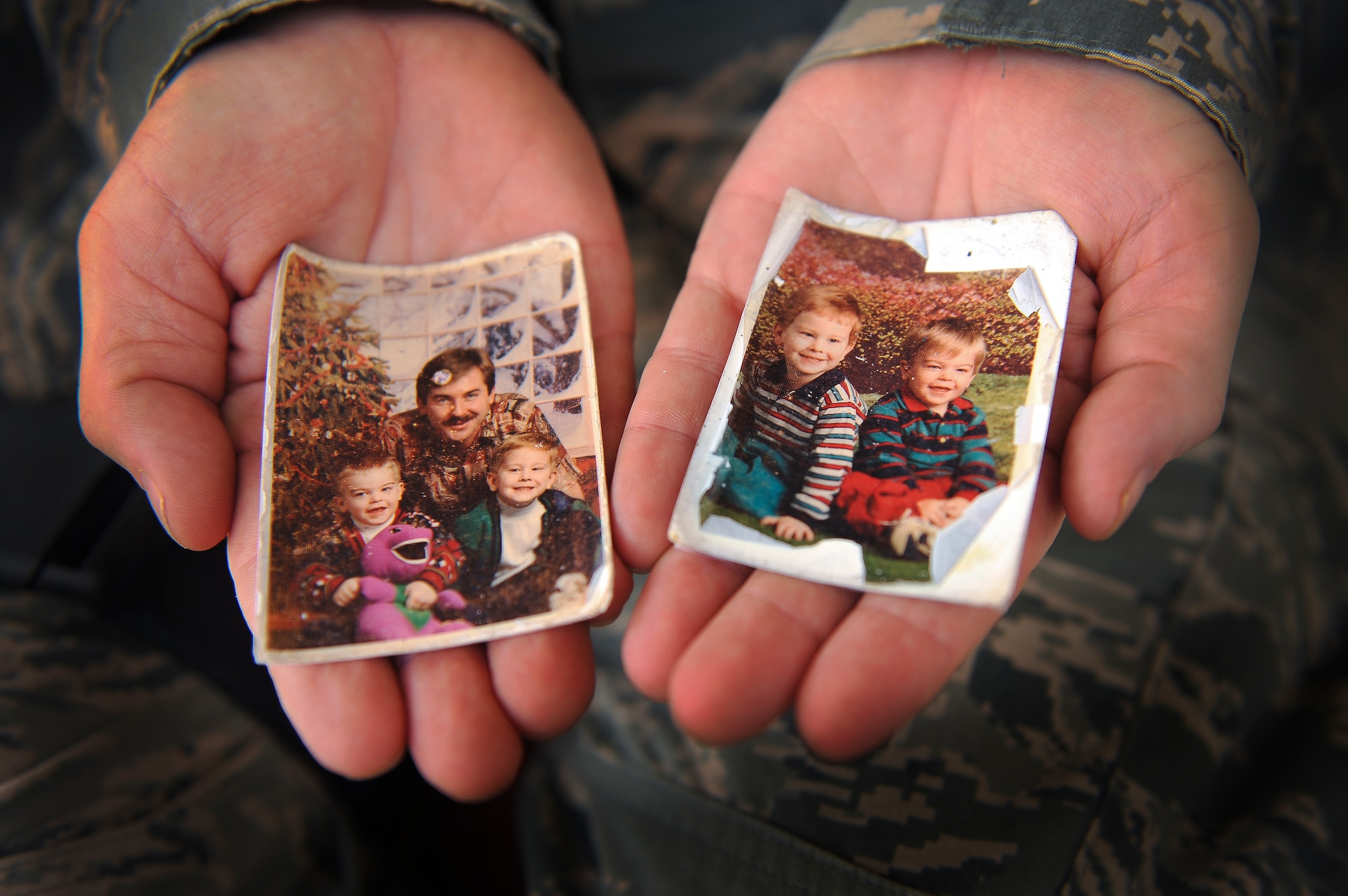 Staff Sgt. Ronald Ball displays photos of his sons that he keeps in his wallet June 25, 2014, at an undisclosed location in Southwest Asia. The photos were taken just before the murder of his wife in 1995. (U.S. Air Force photo/Tech. Sgt. Russ Scalf)