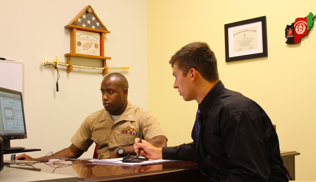 U.S. Marine Corps Capt. Devin Claridy, (left), guides Jamie Gastrich, an officer candidate and a Richmond, Va. native, through his enlistment contract at Officer Selection Station Norfolk in Norfolk, Va., July 7, 2014. Gastrich, a junior at Old Dominion University, became the first candidate to sign an enlistment contract at Recruiting Station Richmond’s newest officer selection station. (U.S. Marine Corps photo by Cpl. Aaron Diamant/Released) 