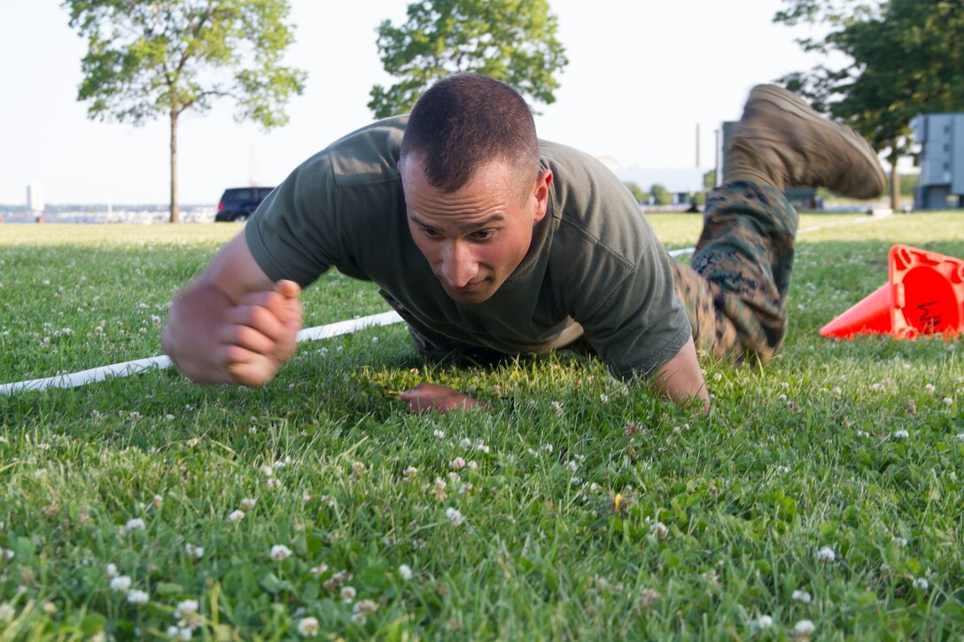 Candidate Alexander Katerinos executes a high crawl during the maneuver under fire portion of the Combat Fitness Test at Veterans Park in Milwaukee, Wis., July 10, 2014.  Officer Selection Station Milwaukee conducted a Combat Fitness Test to help prepare their officer candidates and applicants for Officer Candidates School.