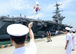 BUSAN, Republic of Korea (July 11, 2014) - Republic of Korea Navy sailors wave South Korean and American flags as the aircraft carrier USS George Washington (CVN 73) arrives in Busan for a port visit. George Washington is forward deployed to Yokosuka, Japan, in the U.S. 7th Fleet area of responsibility supporting regional security and stability in the Indo-Asia Pacific. 