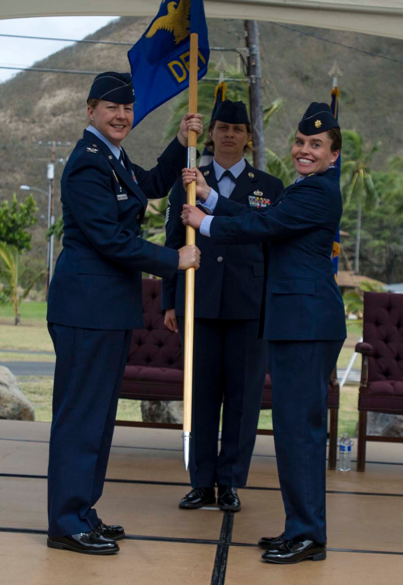 Col. Kathleen Weatherspoon, 18th Force Support Squadron commander, passes the Detachment 2 18th FSS guidon to Maj. Dawn Standridge, Det. 2, 18th FSS commander, during a change of command ceremony at Bellows Air Force station, Hawaii, July 11, 2014. During the ceremony, Standridge took command of the squadron from Maj. Tony Cambron. (U.S. Air Force photo by Tech. Sgt. Terri Paden)