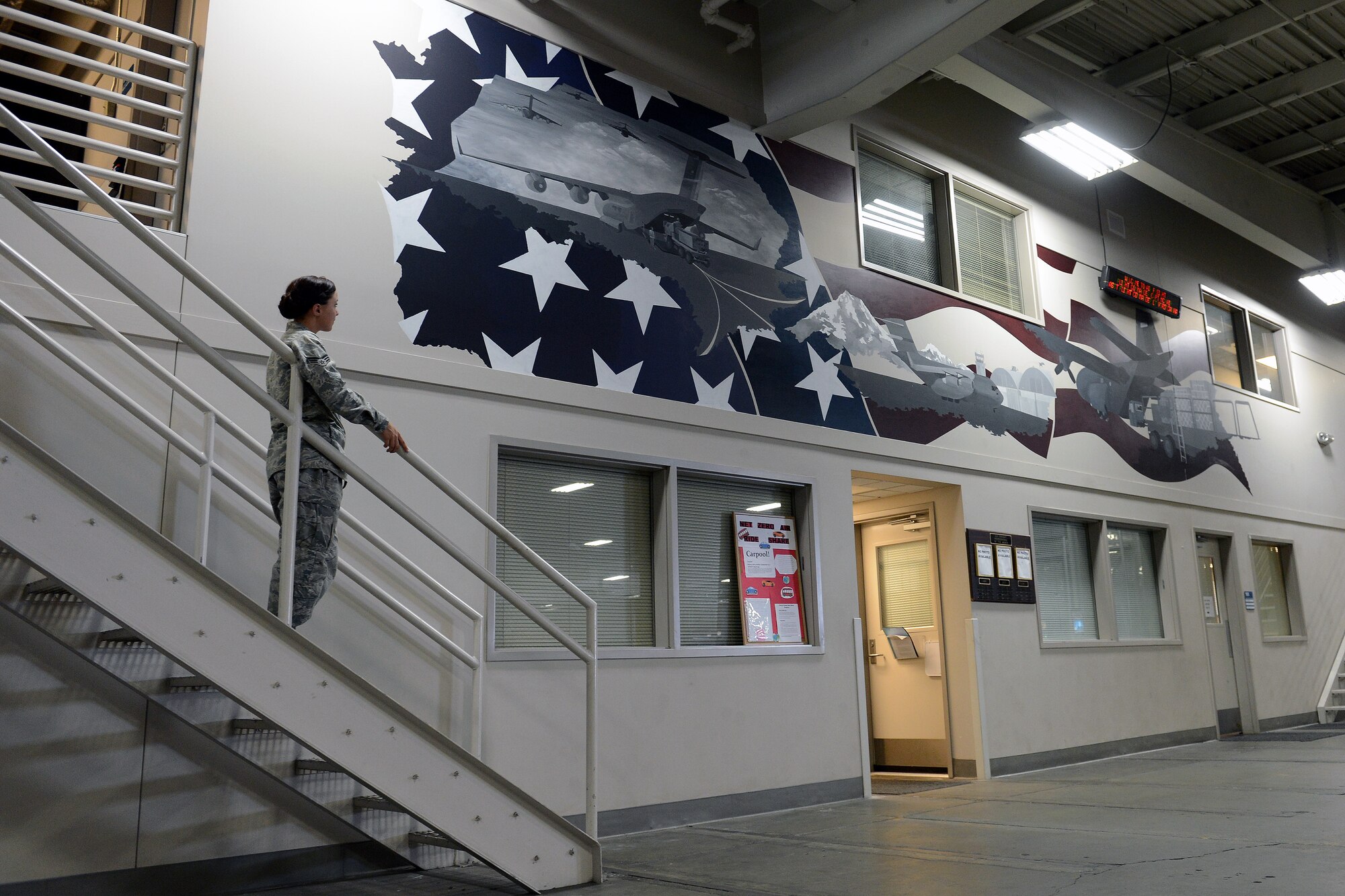 Senior Airman Brittany Kieffer, 62nd Aerial Port Squadron cargo processing element member, inspects a mural she painted for her squadron July 11, 2014, at Joint Base Lewis-McChord, Wash. Kieffer single-handedly painted the 20 feet by 6 feet mural in two months. (U.S. Air Force photo/Airman 1st Class Jacob Jimenez)