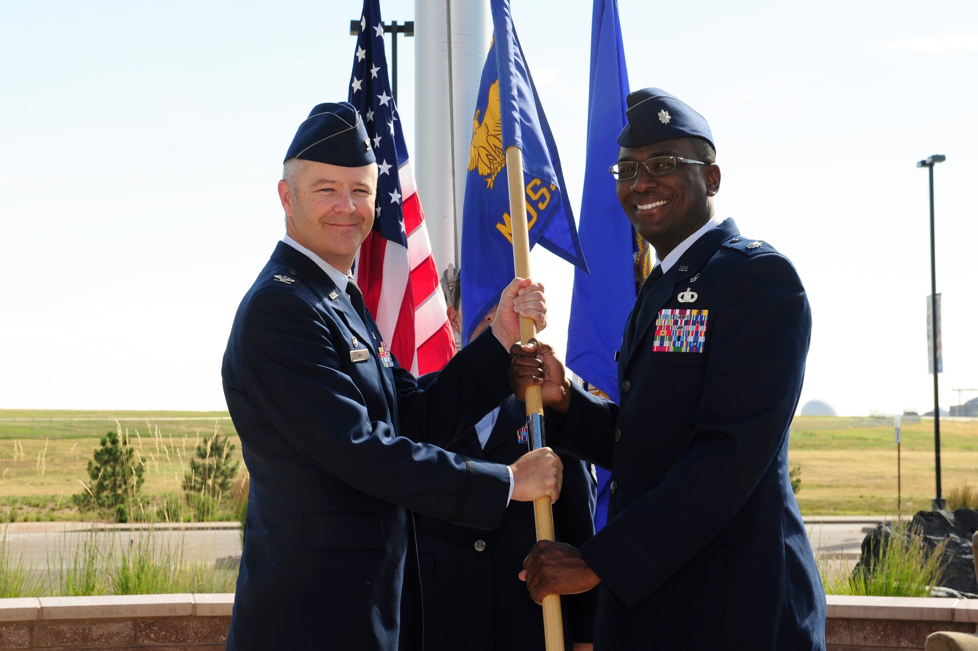 Lt. Col. Alvin Scott, 460th Medical Support Squadron commander, right, receives the 460th MDSS guidon from Col. Michael Kindt, 460th Medical Group commander, during the 460th MDSS change-of-command Ceremony July 11, 2014, at the 460th Space Wing headquarters building on Buckley Air Force Base, Colo. The event signaled Scott’s assumption of command from Lt. Col. Pamela Smith. (U.S. Air Force photo by Airman 1st Class Samantha Saulsbury/Released)