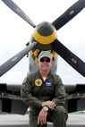 Larry Lumpkin, P-51 Gunfighter Mustang pilot, poses in front of the aircraft for a media photo shoot just outside of the Commemorative Air Force hangar at the Council Bluffs Municipal Airport, Iowa on June 27. Lumpkin along with his co-pilot Jeff Linebaugh and maintainer Jerry Mason have kept the vintage Mustang soaring over air show attendees for the past eight years. Mason has been the sole maintainer of the P-51 Mustang for more than 30 years.  (U.S. Air Force photo by Josh Plueger/Released)