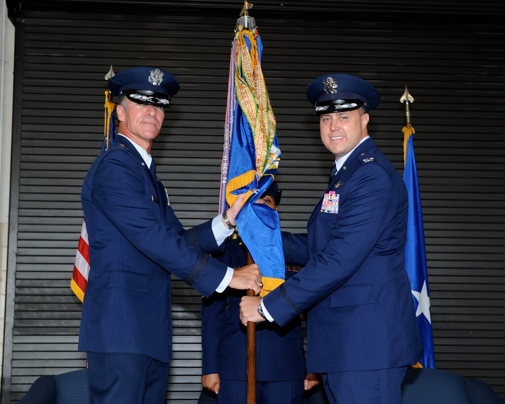 Maj. Gen. Michael Keltz, Air Education and Training Command Director of Intelligence, Operations and Nuclear Integration, hands the 14th Flying Training Wing Guidon to Col. John Nichols during a change of command ceremony at Columbus Air Force Base, Miss. July 11, 2014. Before assuming command of the 14 FTW, Nichols was Chief of the Combat Plans Division, 609th Air Operations Center, Al Udeid Air Base, Qatar. (U.S. Air Force photo/ Elizabeth Owens)