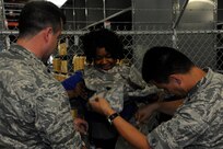 Paula Gold-Williams, a 502nd Air Base Wing honorary commander, tries on body armor with the assistance of Lt. Col Tom Hoskins, 502nd Contracting Squadron commander, and Lt. Col. Glenn Garay, 502nd Installation Support Group deputy commander, July 2, 2014 at the Joint Base San Antonio-Randolph Del Torro Deployment Readiness Center. Members of the 502nd ABW Honorary Commanders Program toured JBSA-Randolph and Fort Sam Houston in order to build stronger relationships with members of the local community. (U.S. Air Force photo by A1C Stormy D. Archer/Released)