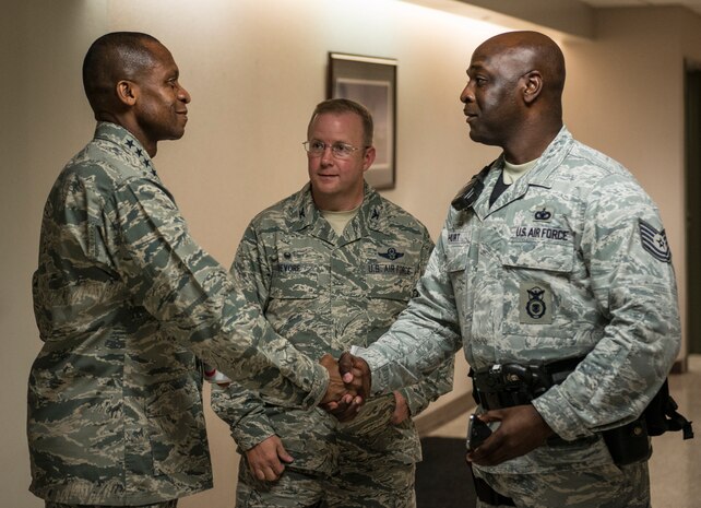Gen. Darren McDew, Air Mobility Commander commander, coins Tech. Sgt. Dwayne Hurt, 628th Security Forces Squadron patroleman July 11, 2014, at Joint Base Charleston, S.C. McDew visited JB Charleston to get a firsthand look at how joint basing builds closer relationships and forges stronger ties between our sister services. (U.S. Air Force photo/Senior Airman Dennis Sloan)