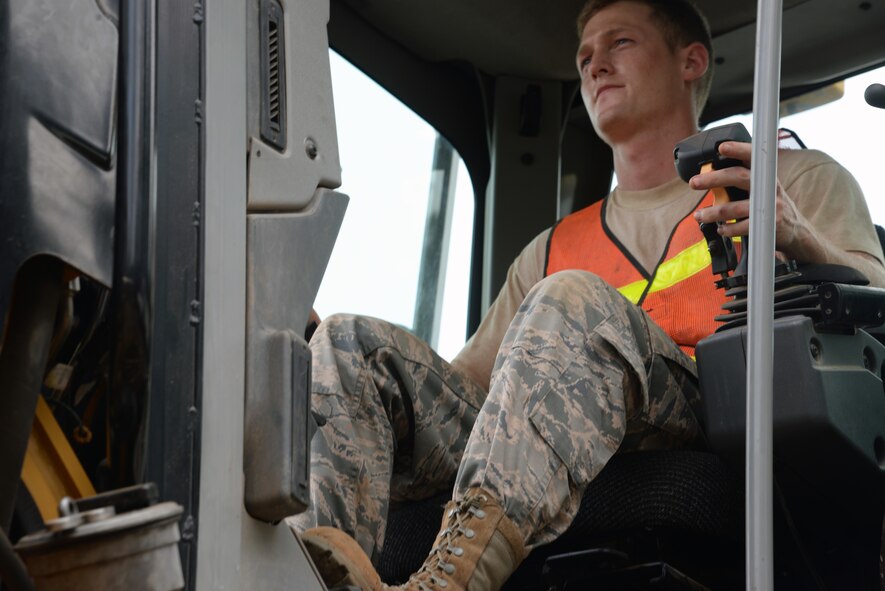 A U.S. Air Force Airman with the 823rd Rapid Engineer Deployable Heavy Operational Repair Squadron Engineers operates a CAT 12M3 grader to backfill a section of Patrol Road at Shaw Air Force Base, S.C., July 10, 2014. The CAT 12M3 uses a 12 foot blade on the bottom of the grader to push dirt and spread out piles along the section of road. (U.S. Air Force photo by Airman 1st Class Jonathan Bass/Released)