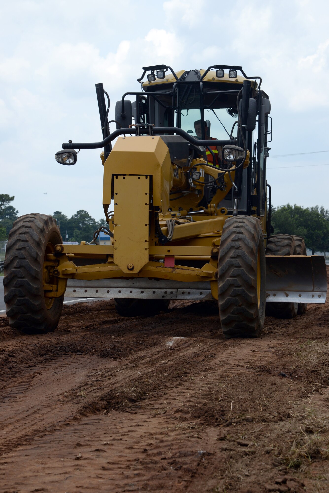 A U.S. Air Force Airman with the 823rd Rapid Engineer Deployable Heavy Operational Repair Squadron Engineers uses a CAT 12M3 grader on a section of Patrol Road at Shaw Air Force Base, S.C., July 10, 2014. The CAT 12M3 was used to backfill the sides of the road in order to prevent asphalt loss as cars drive on the road. (U.S. Air Force photo by Airman 1st Class Jonathan Bass/Released)