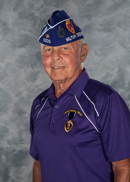 U.S. Air Force retired Chief Master Sgt. Earl Hendrix poses for a photo wearing a cap displaying the patches he acquired during his 30 year career and a shirt showing a purple heart at Moody Air Force Base, Ga., July 10, 2014. The shirt is a symbol of the purple heart Hendrix received after being wounded during combat. (U.S. Air Force Airman 1st Class Alexis Millican/Released)