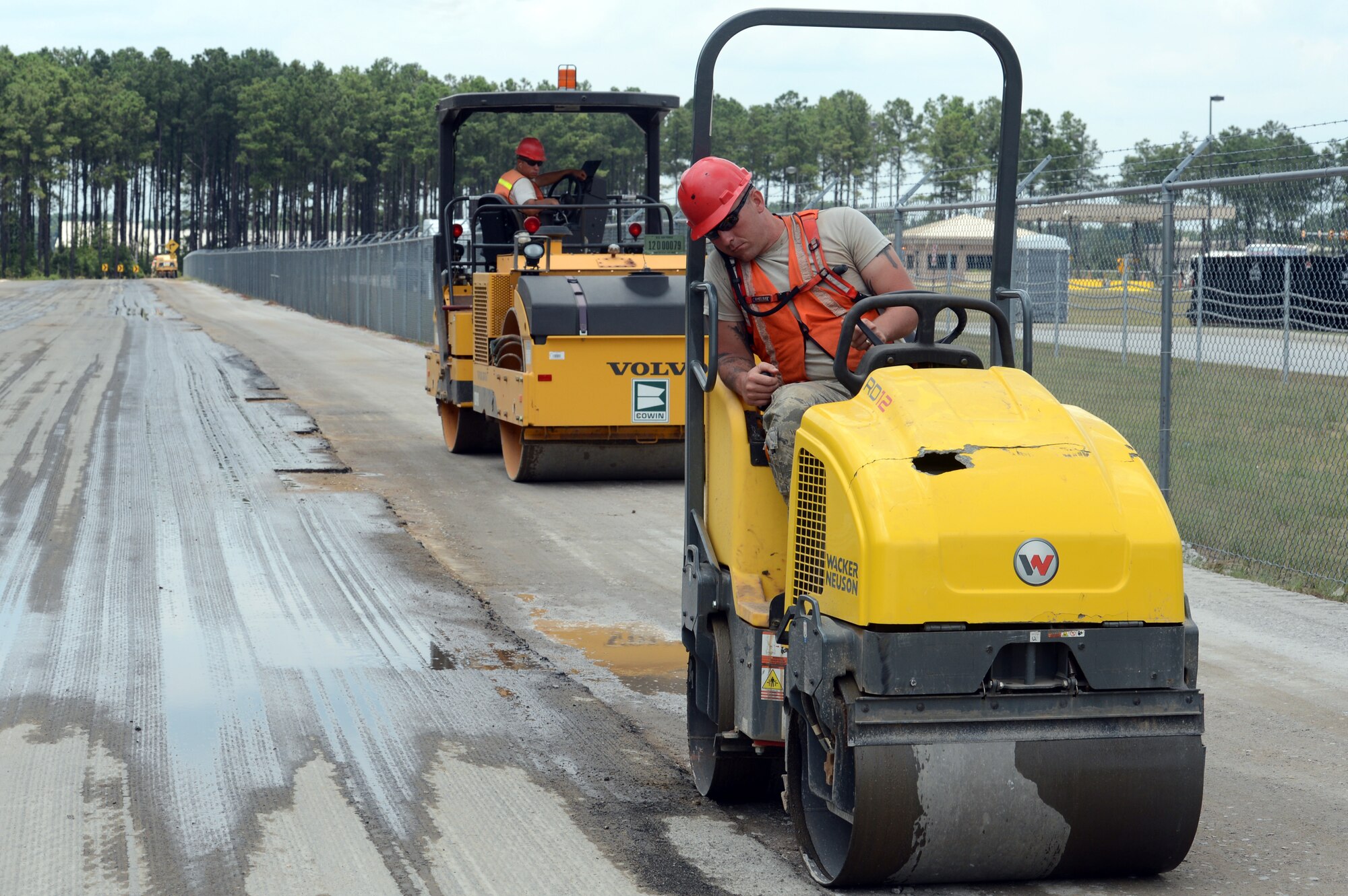 U.S. Air Force Airmen with the 823rd Rapid Engineer Deployable Heavy Operational Repair Squadron Engineers, use steel wheel rollers to smooth out a section of Patrol Road at Shaw Air Force base, S.C., July 10, 2014. The Airmen from the 823rd RED HORSE are scheduled to complete the work by the end of July. (U.S. Air Force photo by Airman 1st Class Jonathan Bass/Released)