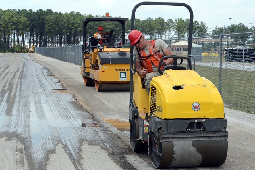 U.S. Air Force Airmen with the 823rd Rapid Engineer Deployable Heavy Operational Repair Squadron Engineers, use steel wheel rollers to smooth out a section of Patrol Road at Shaw Air Force base, S.C., July 10, 2014. The Airmen from the 823rd RED HORSE are scheduled to complete the work by the end of July. (U.S. Air Force photo by Airman 1st Class Jonathan Bass/Released)