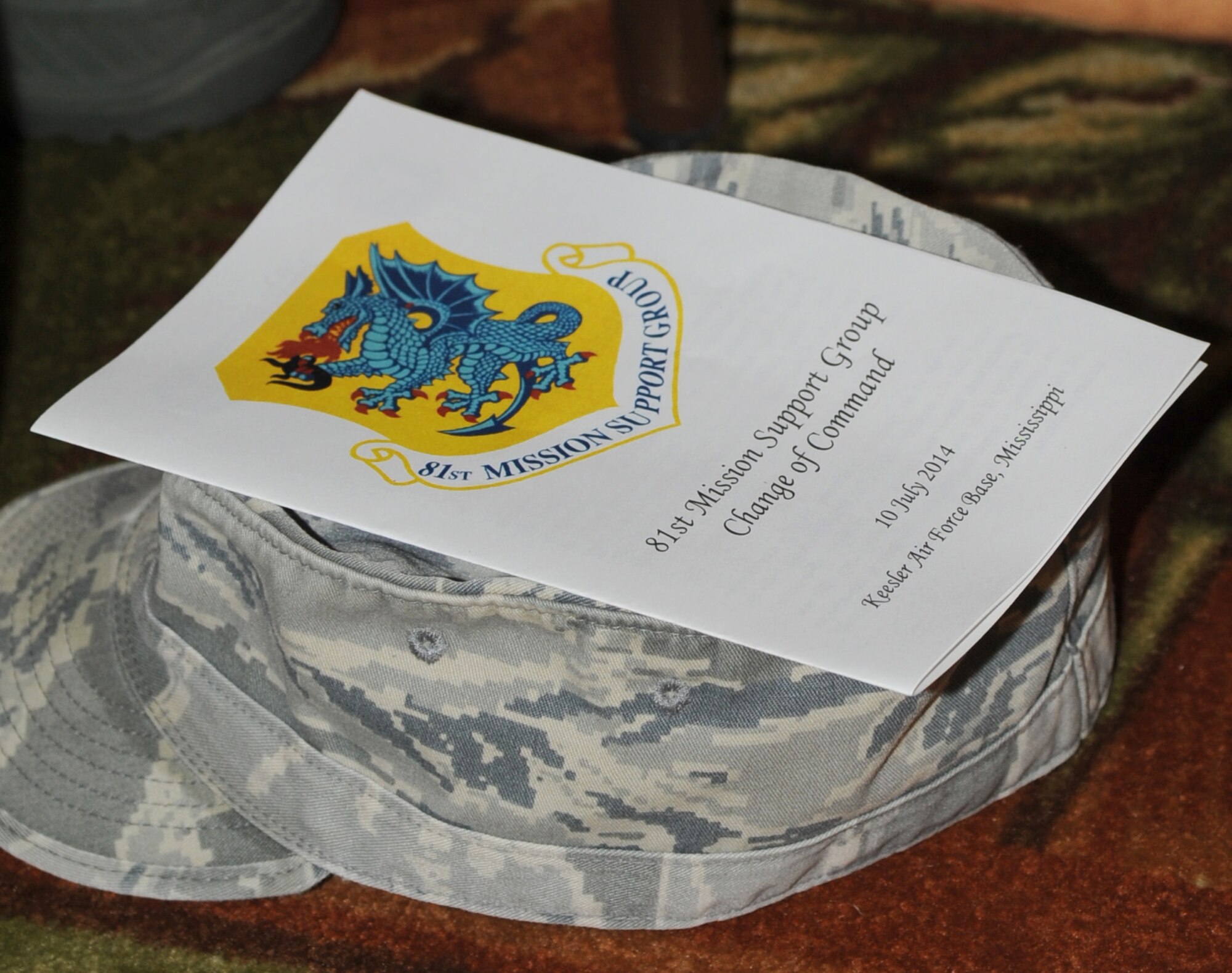 A program sits on top of an Airman battlefield uniform hat at the 81st Mission Support Group change of command ceremony July 10, 2014, at the Bay Breeze Event Center, Keesler Air Force Base, Miss.  Lt. Col. Susan Airola-Skully, incoming commander, was previously the deputy director, officer and enlisted personnel management, for the Under Secretary of Defense for Personnel and Readiness, Office of the Secretary of Defense, at the Pentagon.  She replaces Col. Mark Vivians who will retire July 11.  (U.S. Air Force photo by Kemberly Groue)