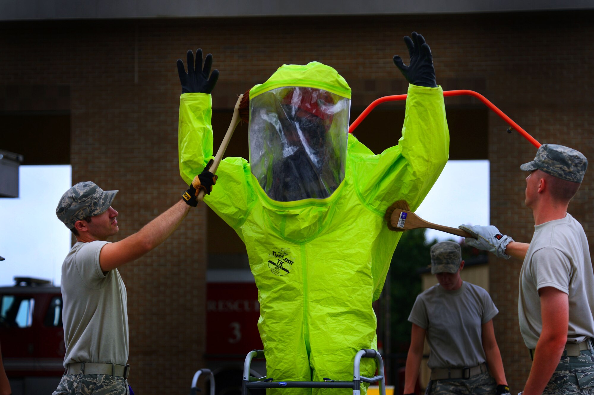 Two 20th Civil Engineer Squadron firefighters scrub a hazardous material suit during training at Shaw Air Force Base, S.C., July 11, 2014. During the training, Airmen practiced decontaminating through a three-step chemical decontamination process. (U.S. Air Force photo by Airman 1st Class Jensen Stidham/Released)  