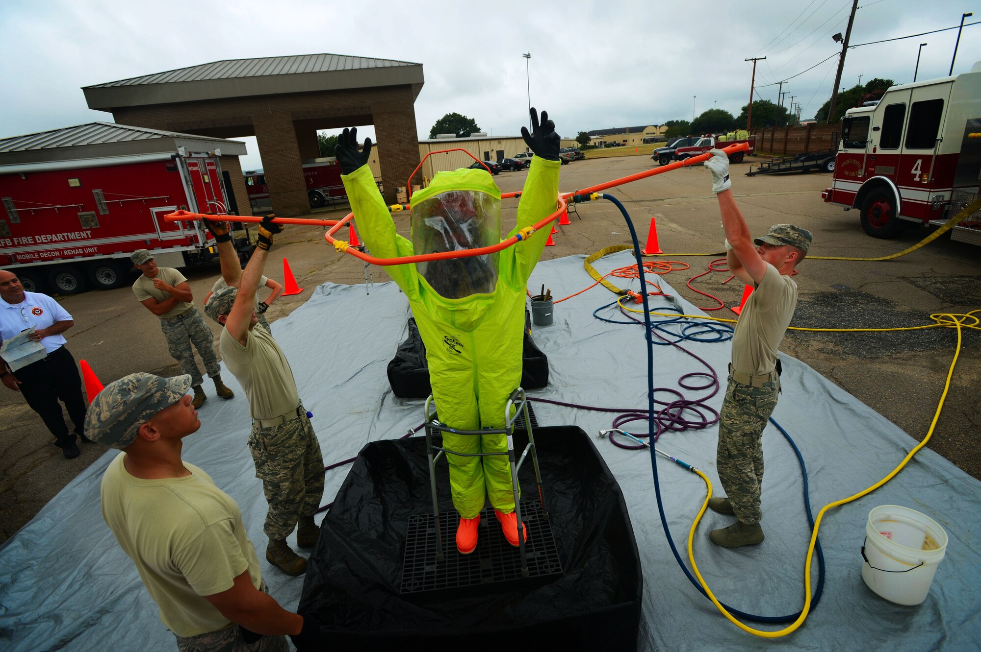 The 20th Civil Engineer Squadron firefighters simulate a hazardous material decontamination at Shaw Air Force Base, S.C., July 11, 2014.  The annual decontamination training was held over the course of two days, starting with classroom briefings and ending with a hands-on ‘walk through’ of the process. (U.S. Air Force photo by Airman 1st Class Jensen Stidham/Released)  
