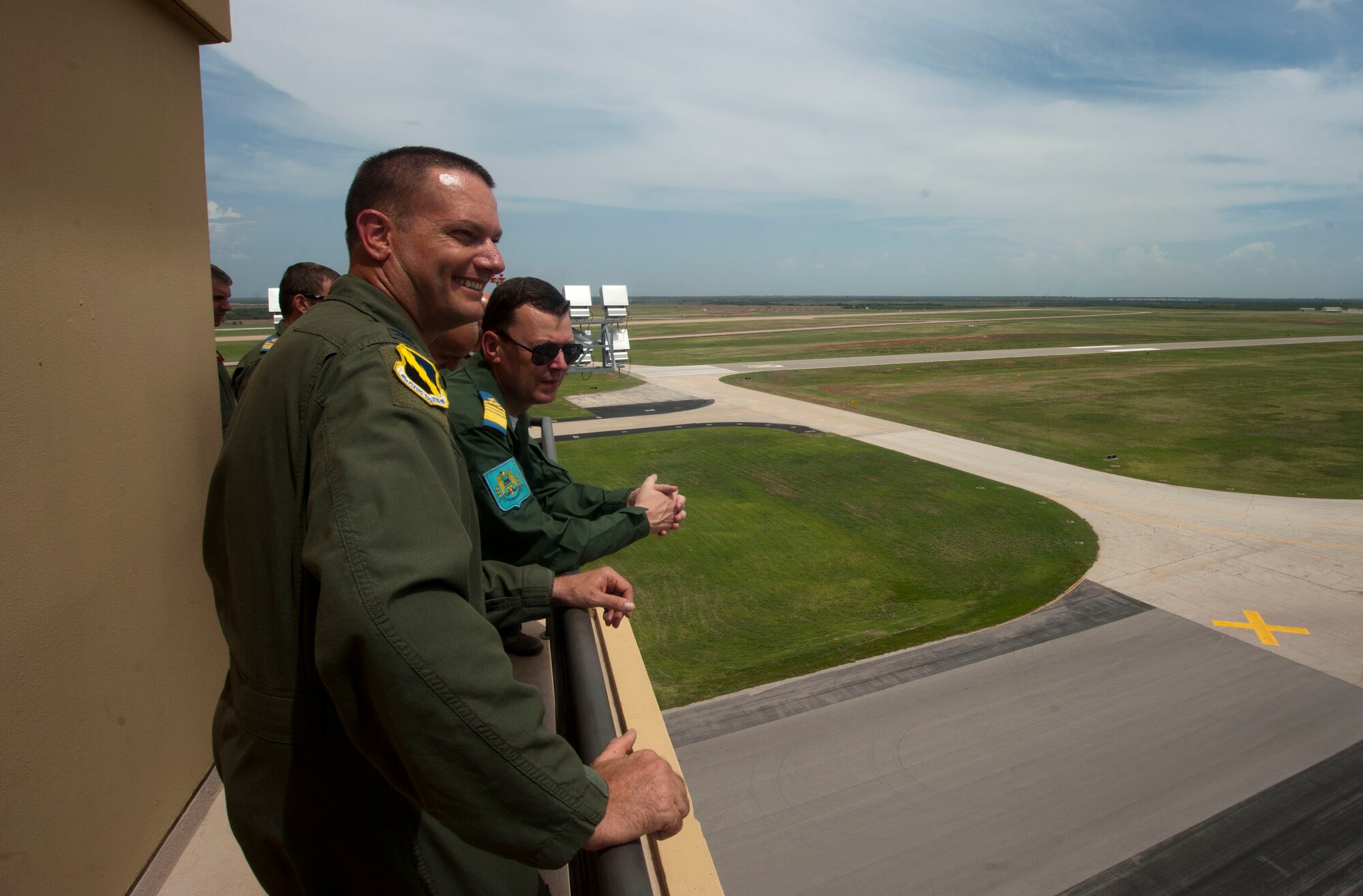 80th Flying Training Wing commander, Col. Lance Bunch, is right at home on the catwalk of the Airfield Operations Complex Control Tower as he shares the wing mission with Romanian Air Force visitors. (U.S. Air Force photo by Airman 1st Class Jelani Gibson)