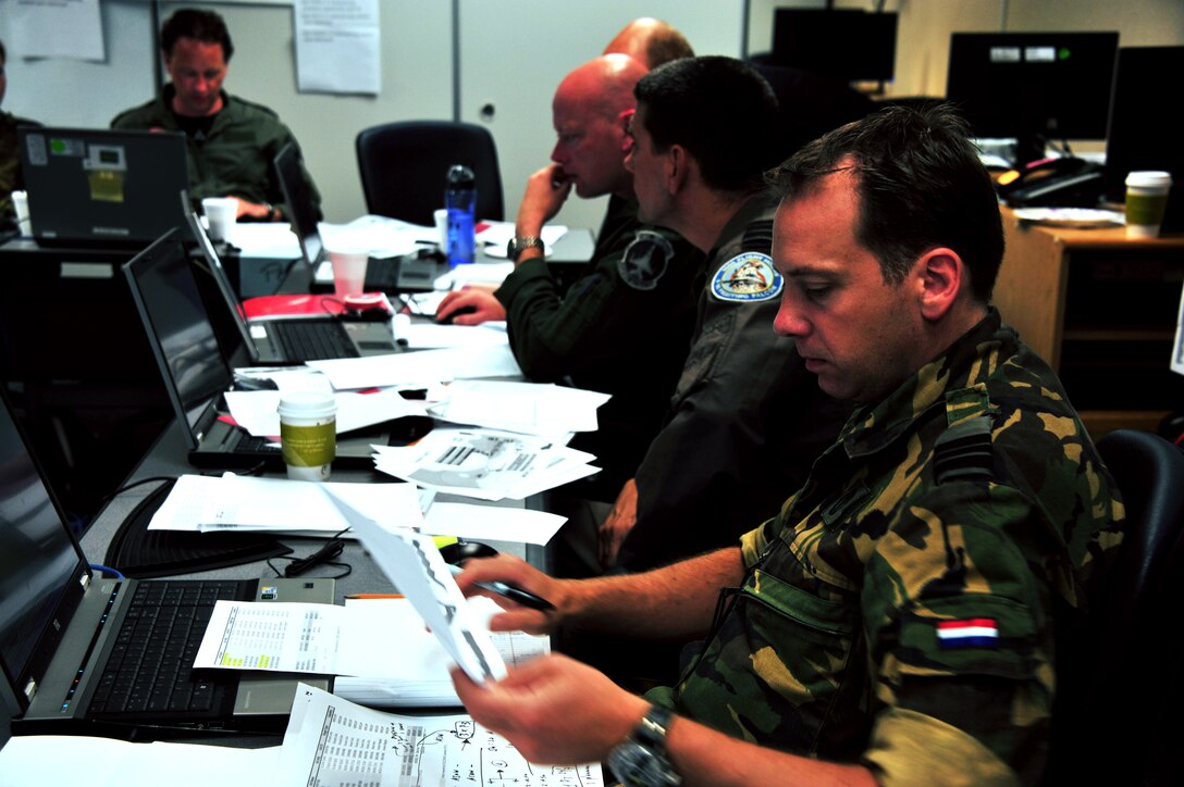 Members of the Royal Netherlands Air Force, Army and Navy coordinate a strategy during the Combined Air Operations Simulation course wargame, hosted by the LeMay Center for Doctrine Development and Education, a part of Air University, at Maxwell June 26, 2014. Each year the Lemay Center hosts a small contingent of Dutch officers to further international relations and helps reinforce the principles of air doctrine before they begin the Joint Advanced Staff Course at the Netherlands Defense Academy. ( U.S. Air Force Photo by Staff Sgt. Gregory Brook)