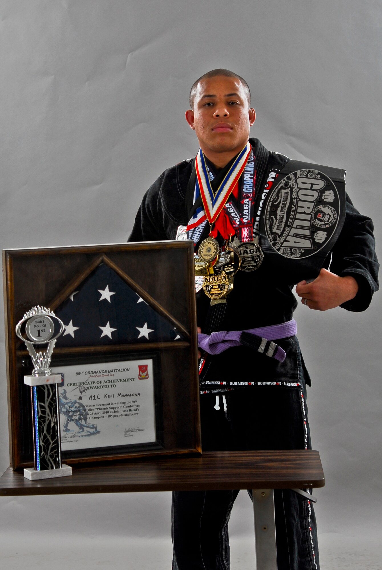 Staff Sgt. Keli Manglona, 56th Maintenance Group aircraft armament specialist, shows off his double striped purple belt for Brazilian Jiu-Jitsu as well as his entire collection of gold, silver and bronze medals June 17 at Luke Air Force Base. Manglona started his career six years ago earning medals and awards from four states and three countries. (U.S. Air Force photo/Airman 1st Class Pedro Mota)