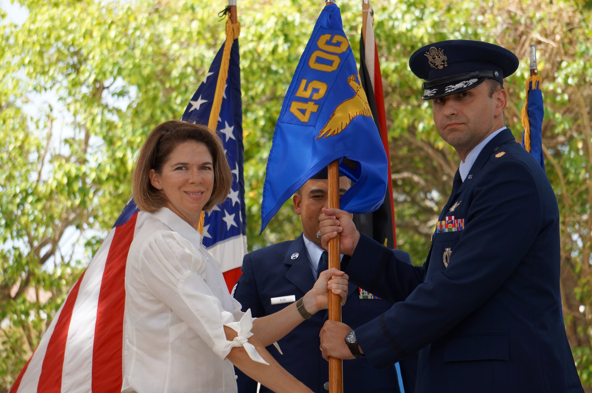 Col. Shannon Klug, 45th Weather Squadron commander and acting Operations Group deputy commander, left, presents Maj. Steven Melvin, 45th Operations Group Detachment 1 commander, with the 45th OG Det. 1 guidon during a change of command ceremony July 7, 2014, at Antigua Air Station, West Indies, Antigua and Barbuda. Changes of command are a military tradition representing the transfer of responsibilities from the presiding officials to the upcoming official. (U.S. Air Force photo/Bruce Wirfs)