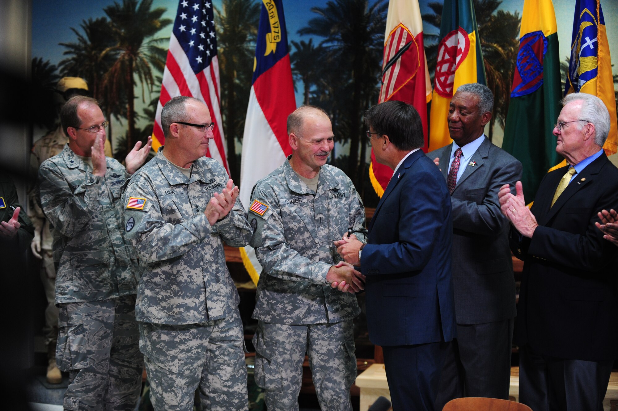 North Carolina Governor Pat McCrory shakes hands with Chief Warrant Officer 5 Richard Comer, State Command Chief Warrant Officer for the North Carolina National Guard, after signing Senate Bill 761, July 10, 2014, in Raleigh, North Carolina.  McCrory signed legislature that will ensure college credits are given to students who have already completed similar training through the military.  Five Airmen were selected from Seymour Johnson Air Force Base, North Carolina to attend the signing.  (U.S. Air Force photo/Airman 1st Class Brittain Crolley) 