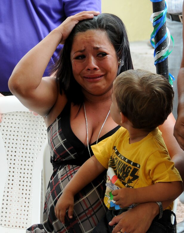 A local Honduran woman cries tears of joy after she receives the keys to her new home during a Habitat for Humanity house dedication in Ajuterique, Department of Comayagua, Honduras, July 5, 2014.  Joint Task Force-Bravo, Honduras Habitat for Humanity-Siguatepeque region, Municipality of Ajuterique officials and other volunteers celebrated with 18 local families as they received the keys to their new homes.  Volunteers from JTF-Bravo worked over 600 hours on Saturdays filling trenches, leveling ground and shoveling dirt at the Ajuterique Housing Project helping these Honduran families construct their homes.  (Photo by U. S. Air National Guard Capt. Steven Stubbs)