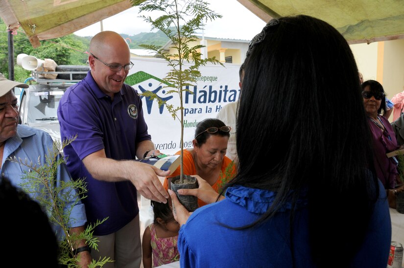 U. S. Army Lt. Col. Nicholas Dickson, JTF-Bravo's Army Forces Battalion commander, hands a local Honduran woman the keys to her new home during a Habitat for Humanity house dedication in Ajuterique, Department of Comayagua, Honduras, July 5, 2014.  Joint Task Force-Bravo, Honduras Habitat for Humanity-Siguatepeque region, Municipality of Ajuterique officials and other volunteers celebrated with 18 local families as they received the keys to their new homes.  Volunteers from JTF-Bravo worked over 600 hours on Saturdays filling trenches, leveling ground and shoveling dirt at the Ajuterique Housing Project helping these Honduran families construct their homes.  (Photo by U. S. Air National Guard Capt. Steven Stubbs)