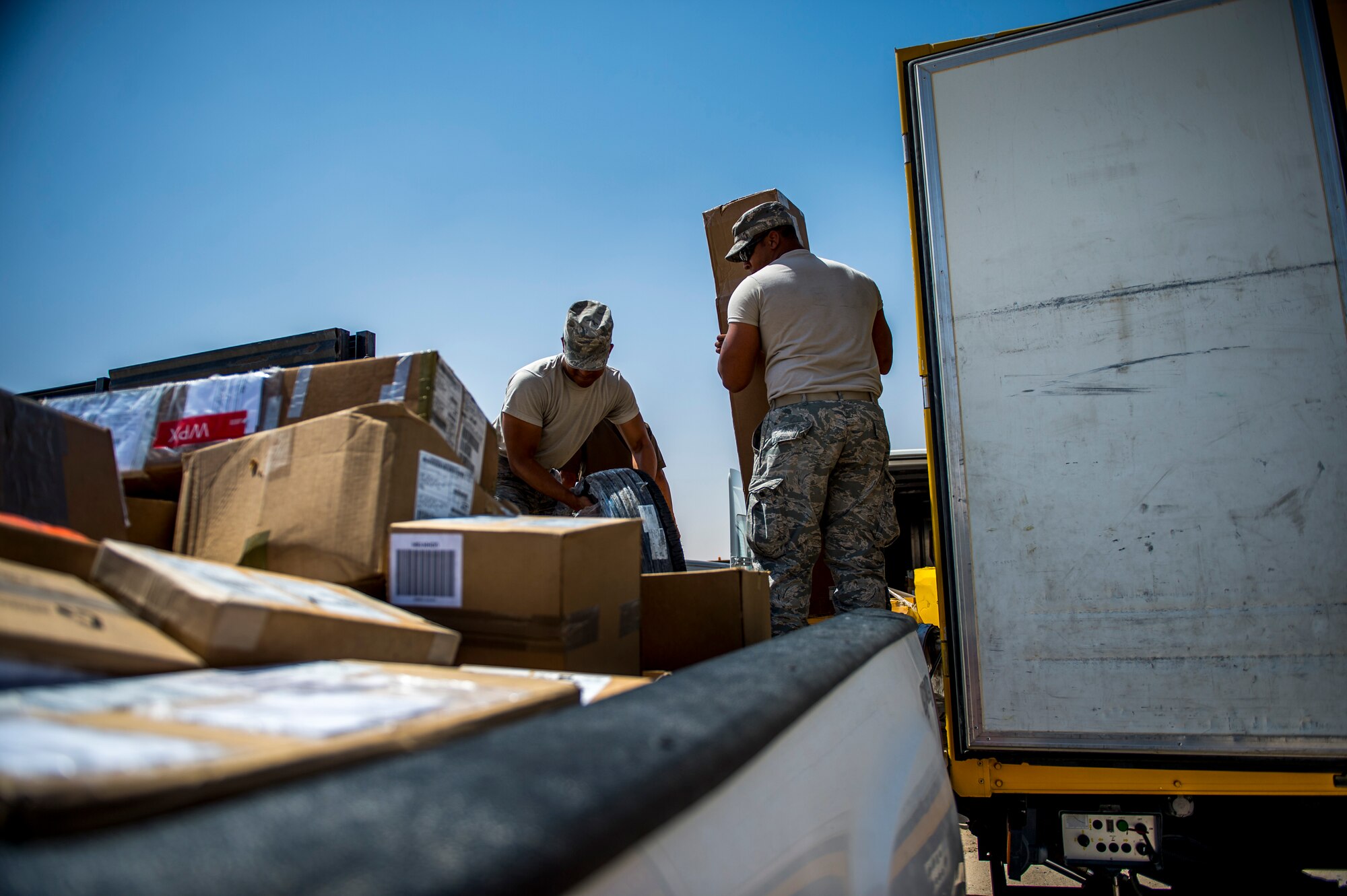 U.S. Air Force Senior Airmen Adam Williams 386th Expeditionary Logistics Readiness Squadron traffic management journeyman, and Christopher Daniels, 386th ELRS inbound cargo processor, load packages from small package carriers into government vehicles May 31, 2014 at an undisclosed location in Southwest Asia. Both Airmen deployed from the 6th LRS, MacDill Air Force Base, Florida, in support of Operation Enduring Freedom. (U.S. Air Force photo by Staff Sgt. Jeremy Bowcock)