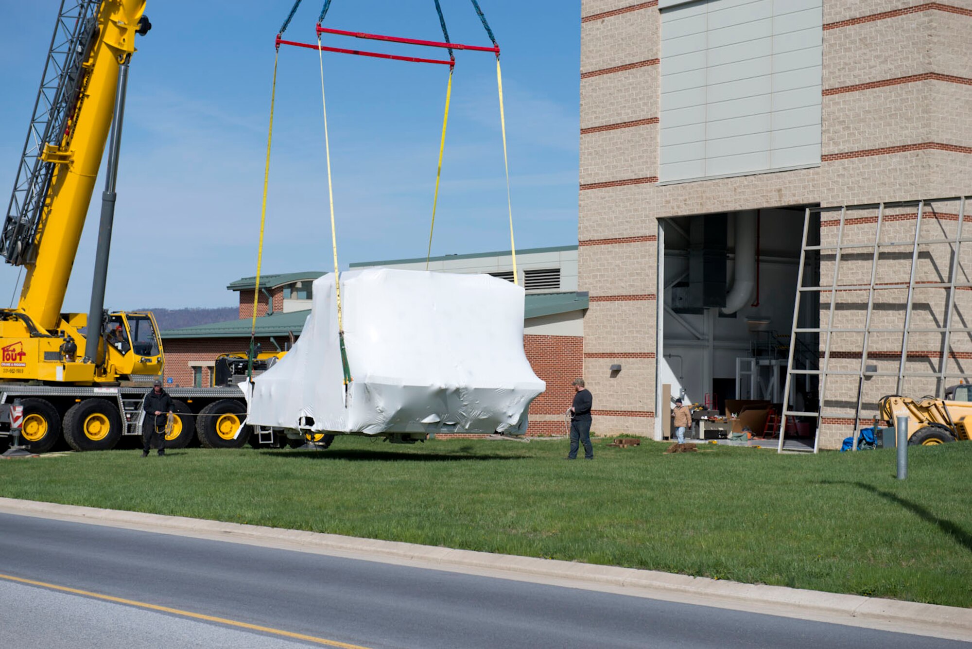 The main body of the C-5 flight simulator is hoisted away from the flight safety building by crane, April 17. The simulator was taken to Letterkenny Army Depot.(Air National Guard photo by Capt. Christopher Tusing)
