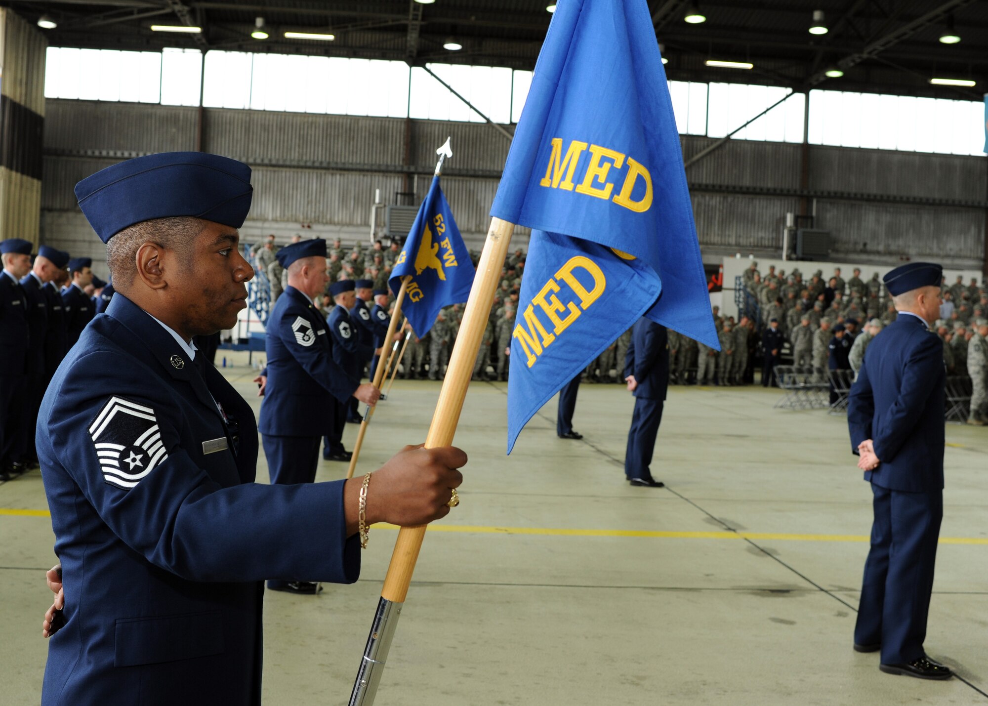 U.S. Air Force Senior Master Sgt. Paul Ellis, 52nd Medical Group acting superintendent, holds the group’s guidon during the 52nd Fighter Wing assumption of command ceremony in Hangar 1 at Spangdahlem Air Base, Germany, July 11, 2014. More than 500 Saber Airmen attended the ceremony where U.S. Air Force Col. Peter Bilodeau assumed command of the wing. (U.S. Air Force photo by Airman 1st Class Dylan Nuckolls/Released)