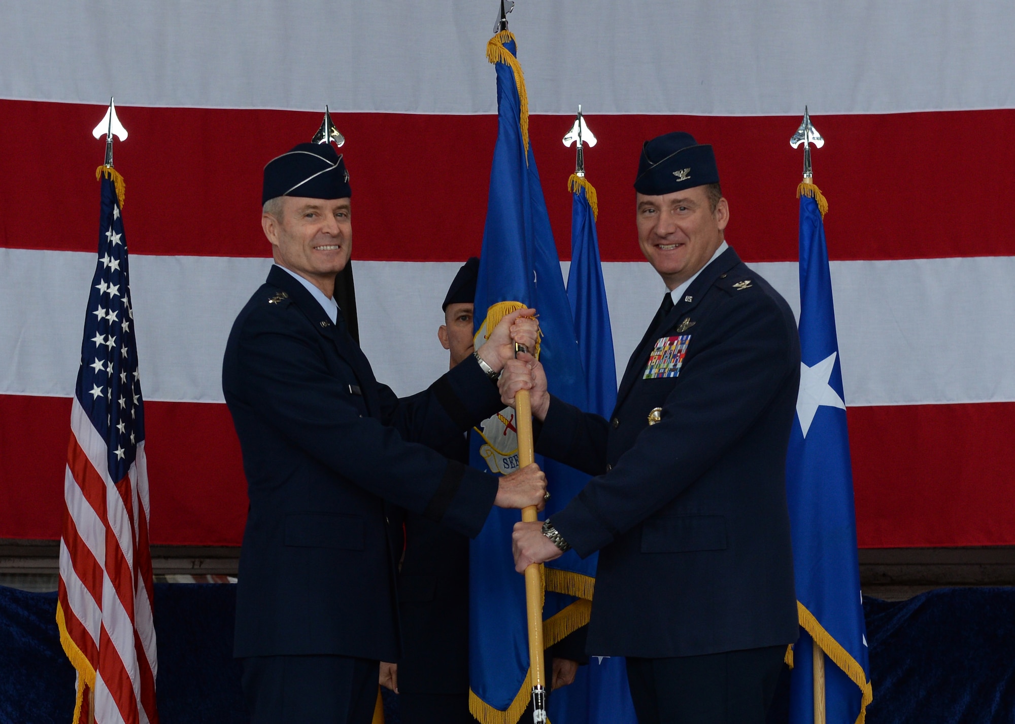 U.S. Air Force Lt. Gen. Darryl Roberson, 3rd Air Force commander, passes the 52nd Fighter Wing guidon to Col. Peter Bilodeau, 52nd Fighter Wing commander, during an assumption of command ceremony July 11, 2014, at Spangdahlem Air Base, Germany. Bilodeau assumed command of five groups, 24 squadrons, 16 geographically separated units spread across five countries with approximately 4,500 active duty military members, 6,000 family members, 250 U.S. civilians, 850 host-nation employees and 300 retirees. (U.S. Air Force photo by Staff Sgt. Daryl Knee/Released)