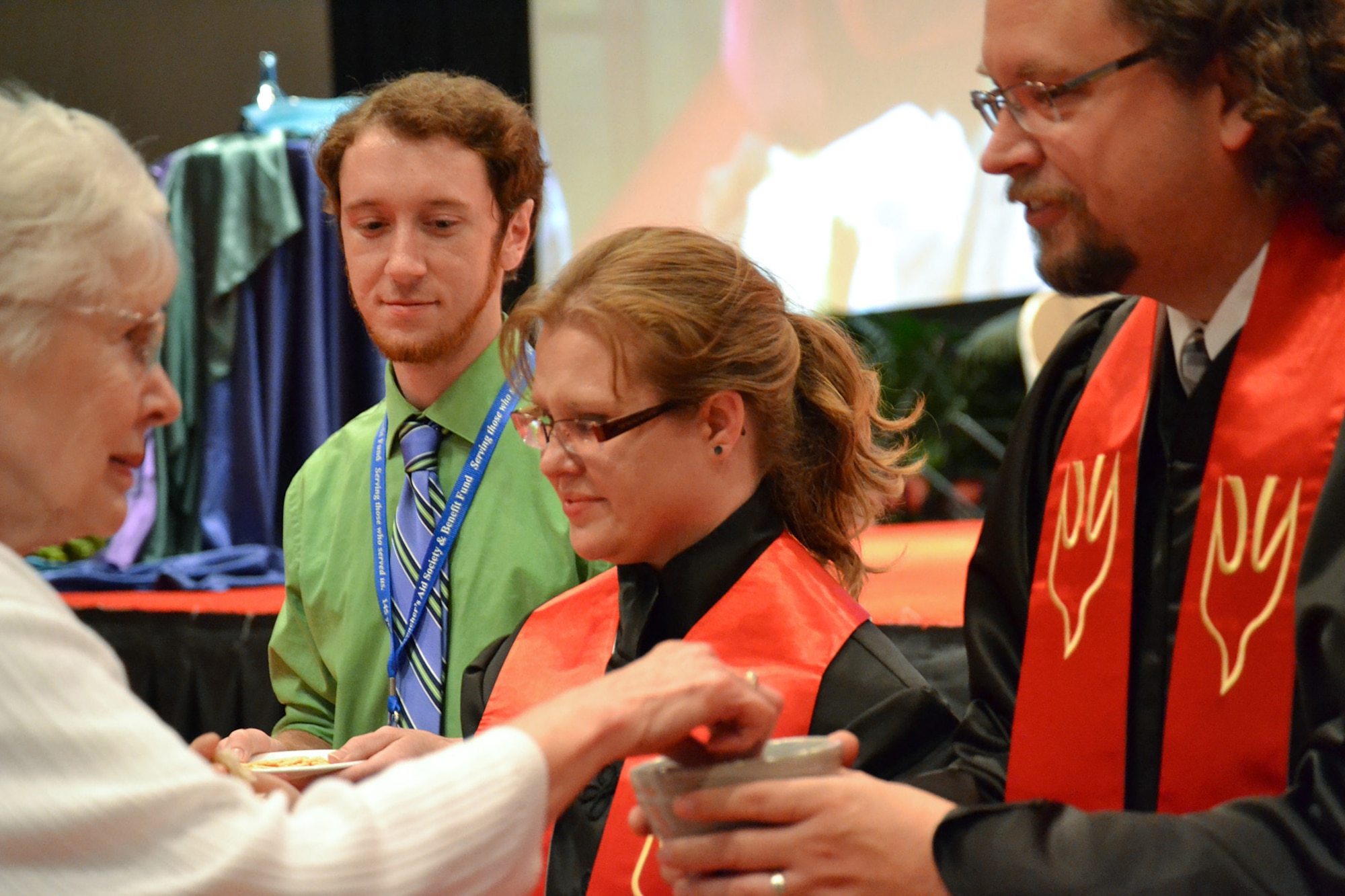 U.S. Air Force Chaplain (Capt.) Kristi L. Hopp, center, serves communion during her ordination ceremony in Peoria, Ill., June 6, 2014. The United Methodist Church ordained Hopp after completing an 8-year process of education and evaluation. She first became interested in the military during a Veterans Affairs hospital internship. “The stressors that we all are under in the Guard and being deployed are different. And yeah, sometimes we come back wounded, but then that’s kind of what war does,” she said. “It might not always wound us on the outside, but it can wound us on the inside. And so, it’s a very rewarding ministry to be able to serve here.” (Photo courtesy from Chaplain (Capt.) Kristi L. Hopp/Released)