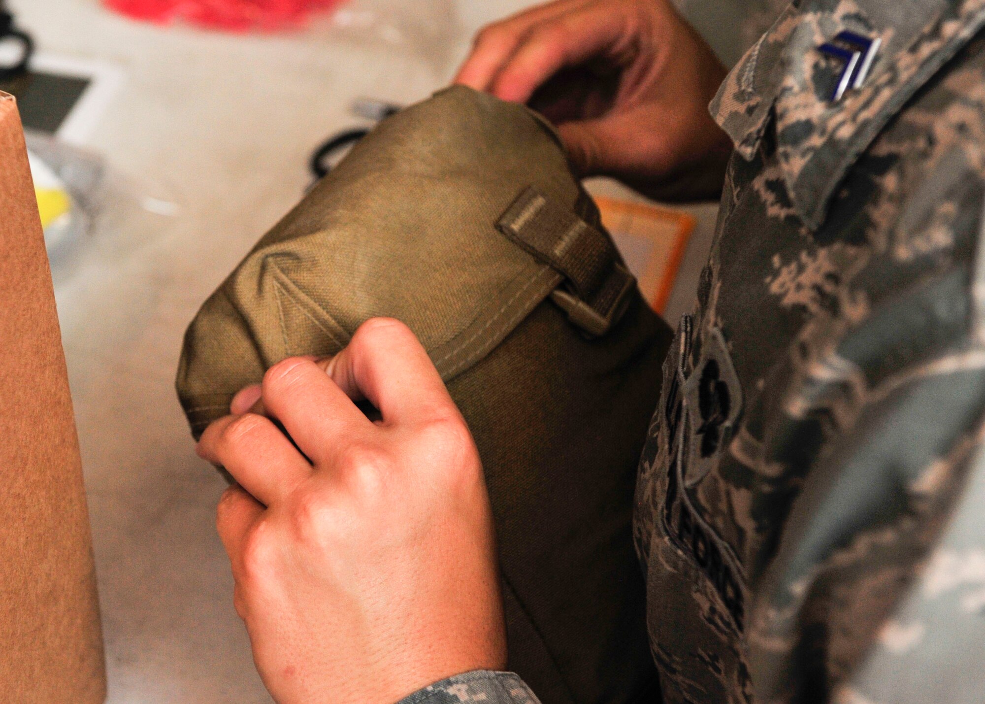 U.S. Air Force Academy Cadet, secures the pouch for a Individual First Aid Kit at Al Udeid Air Base, Qatar, June 30, 2014. Cadets visited AUAB as part of a the Operation Air Force program to shadow officers and enlisted members to experience the active duty lifestyle. (U.S. Air Force photo by Senior Airman Colin Cates)  