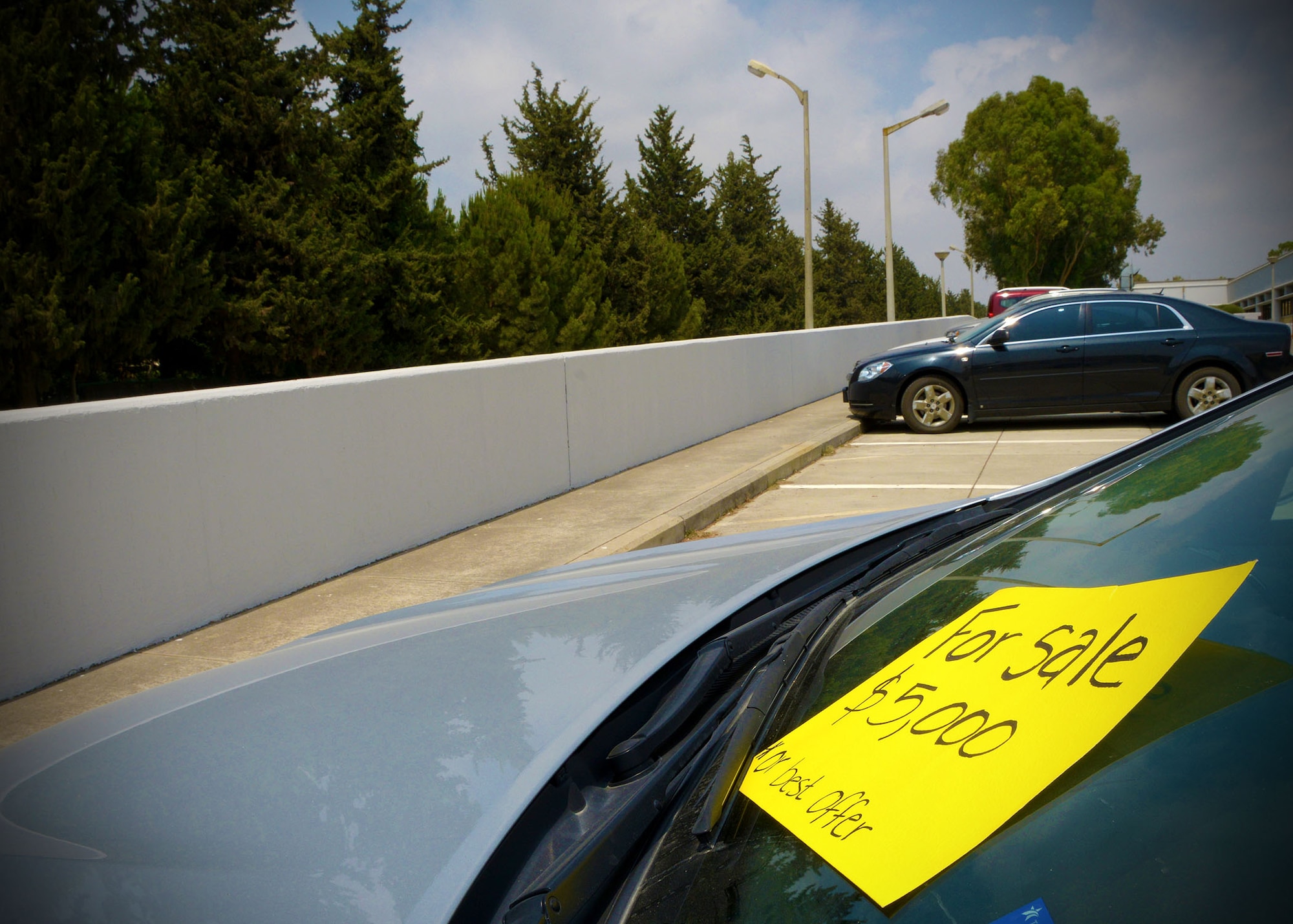 A vehicle sits in a parking lot with a ‘for sale’ sign on the windshield July 11, 2014, Incirlik Air Base, Turkey. Transferring a Privately Owned Vehicle from one U.S. member to another is a process that requires special documentation with command approval and coordination through the Turkish Customs Liaison Office. (U.S. Air Force photo by Staff Sgt. Veronica Pierce) 